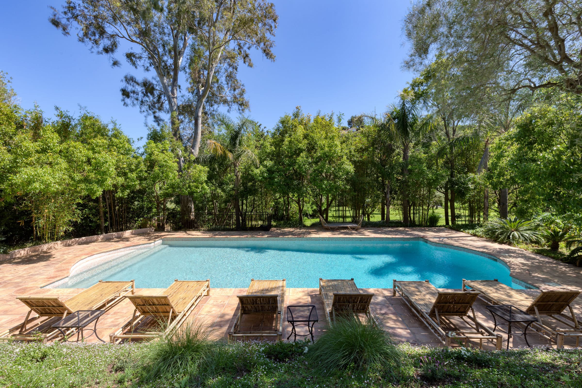 Maison à vendre à Grimaud avec piscine chauffée. Espace détente entouré de verdure et terrasse ensoleillée avec vue sur le château.
