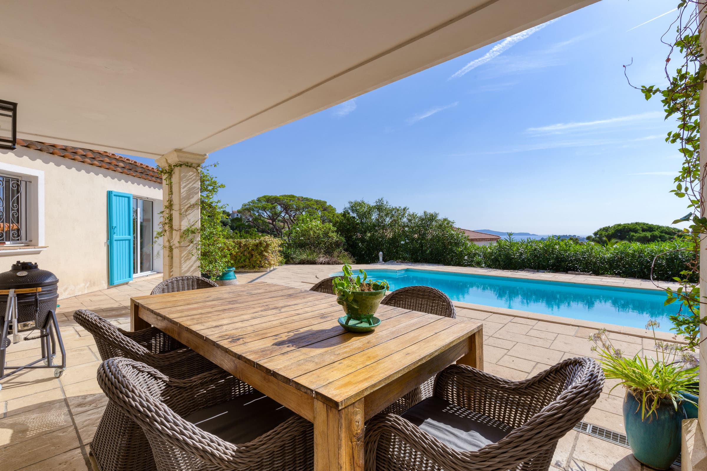 Terrasse ensoleillée avec piscine, vue panoramique sur la mer et jardin paysager, villa récente proche du centre et des plages.
