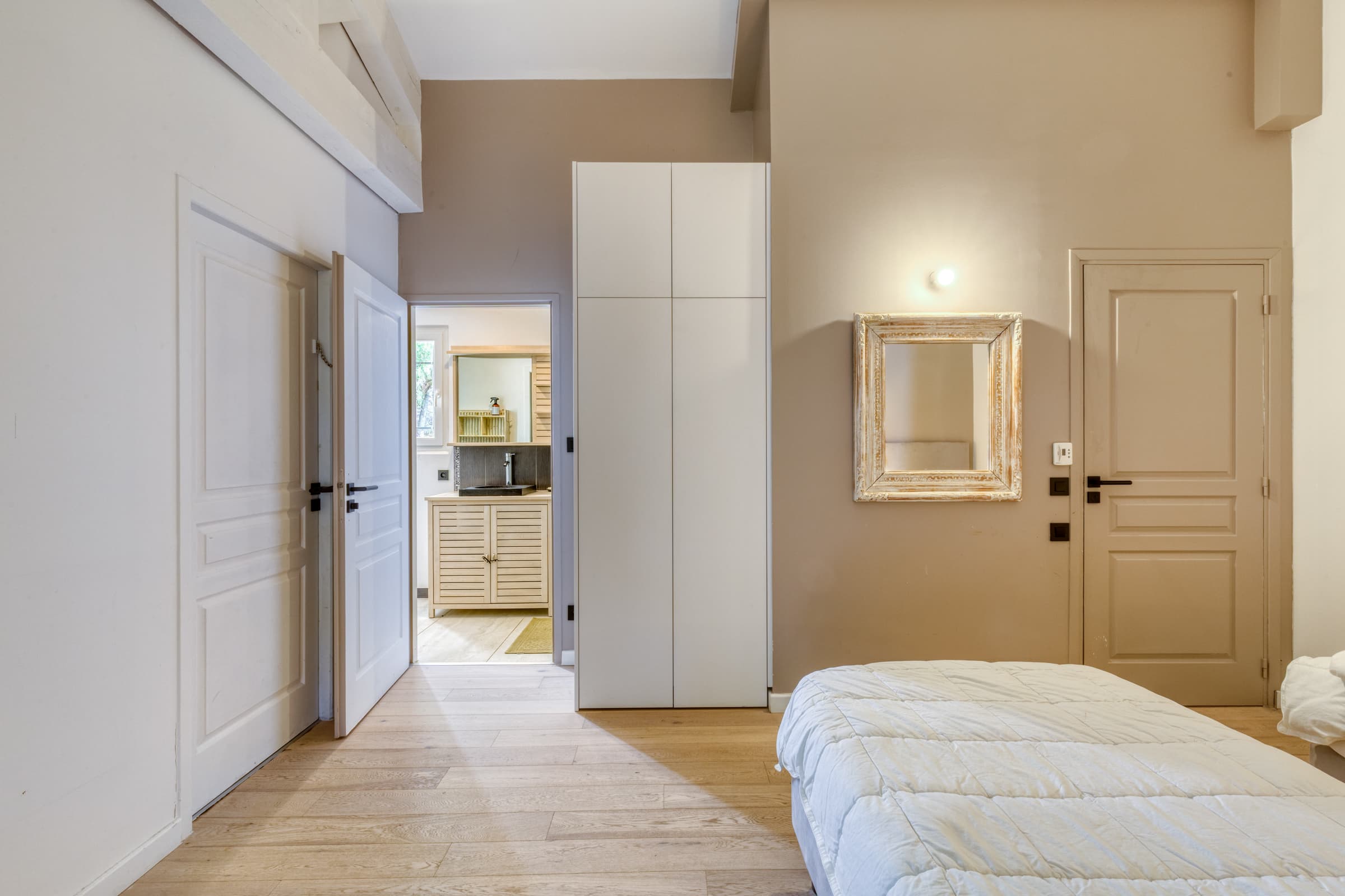 Chambre en suite de la villa à vendre, avec salle d’eau privative et vue sur le jardin.