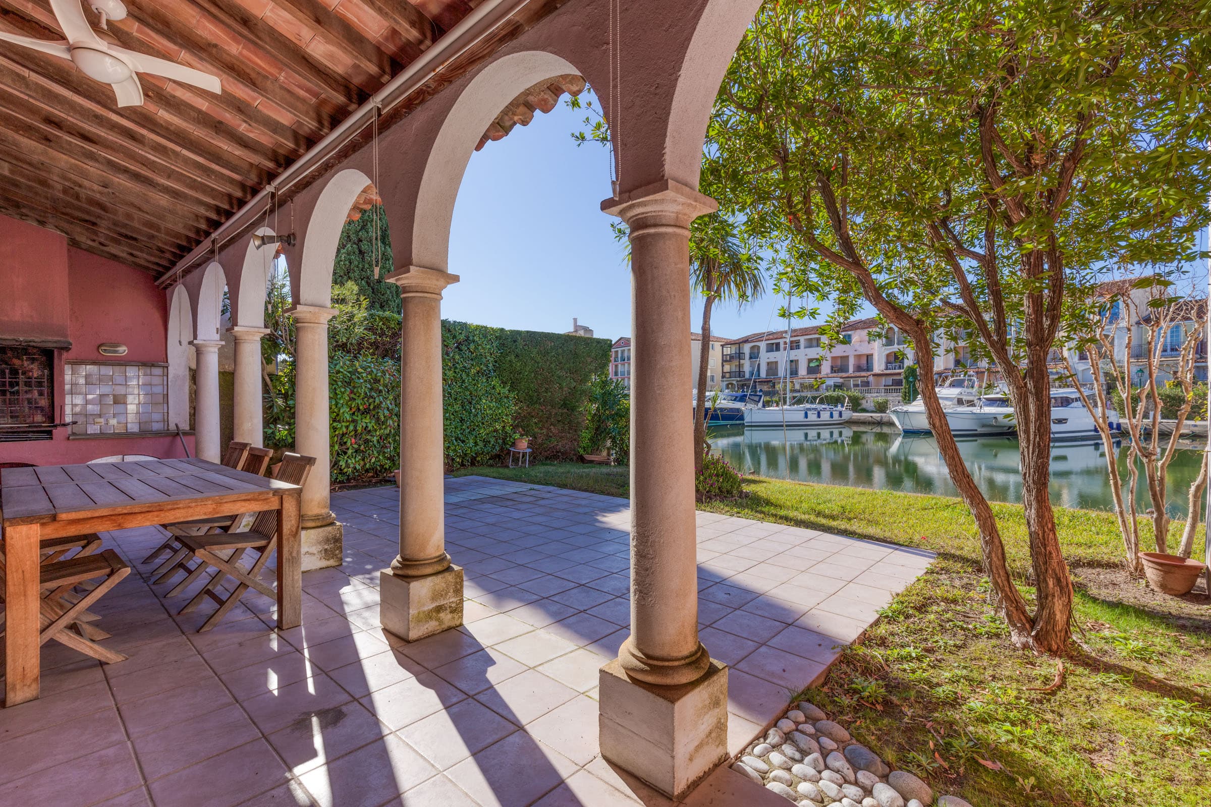 Terrasse ensoleillée sur canal dans propriété à vendre Port-Grimaud avec grands amarrages et ambiance marine unique.