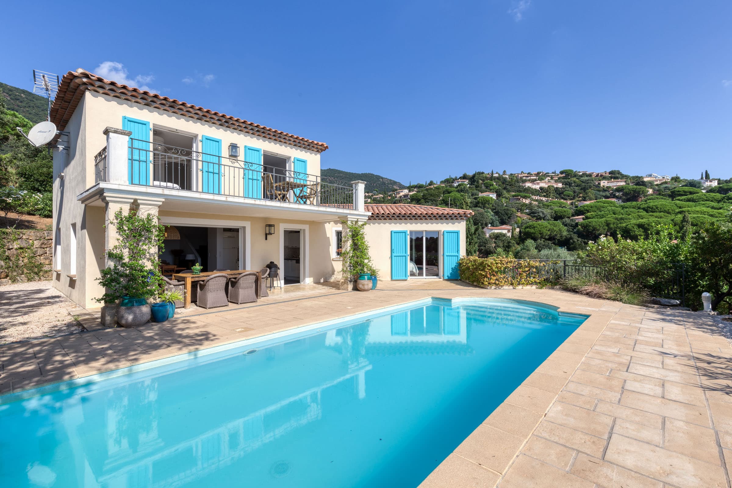 Piscine moderne entourée de terrasse et jardin, villa récente à Cavalaire-sur-Mer avec vue mer et accès direct aux chambres.
