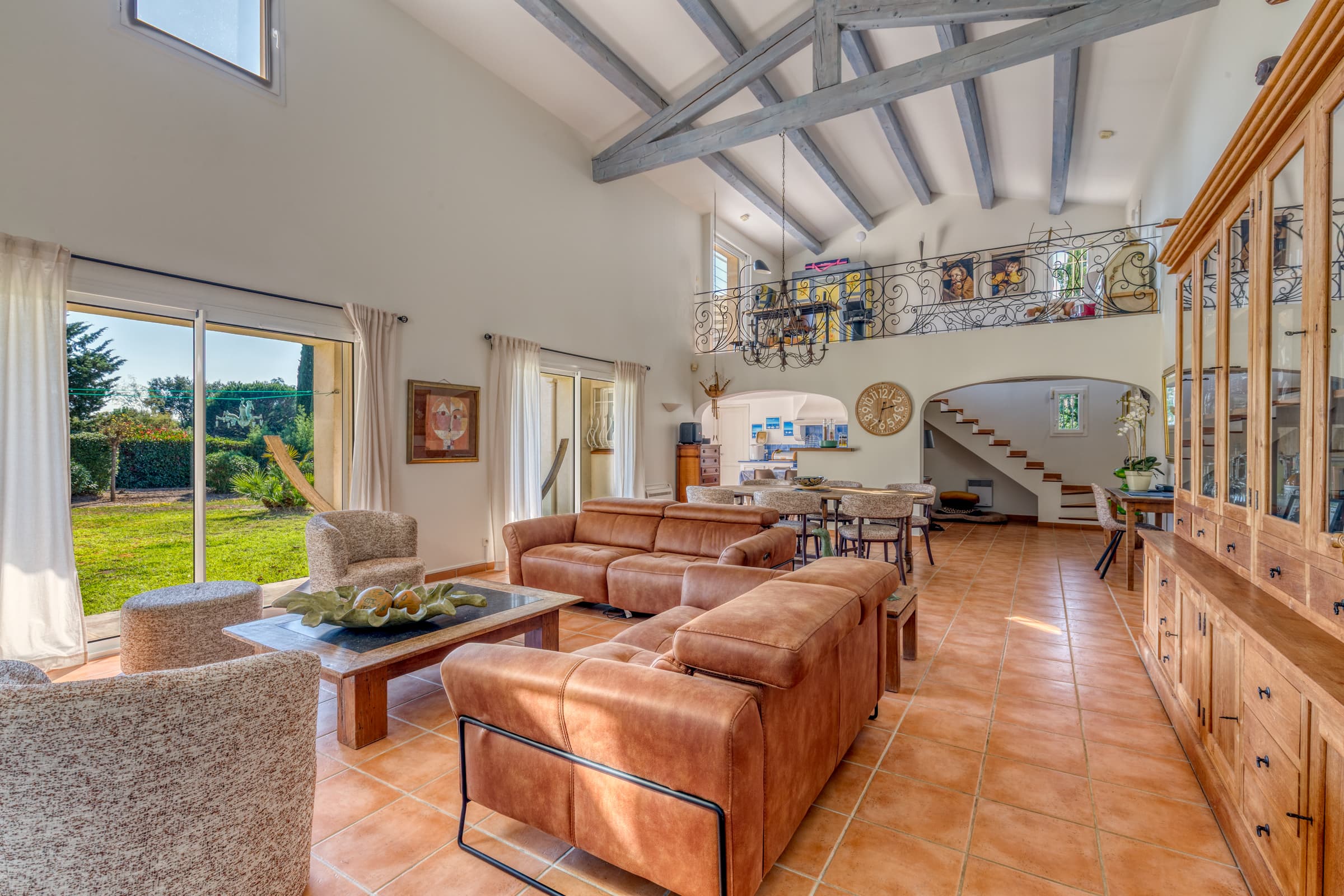Vaste séjour baigné de lumière, ouvert sur le jardin et les terrasses. Charme, espace et élégance au calme.