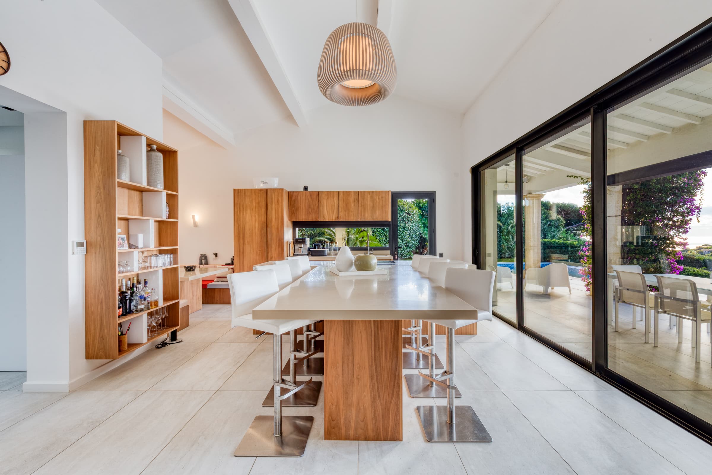 Cuisine contemporaine entièrement équipée de la villa à vendre, ouverte sur les terrasses et la Méditerranée.