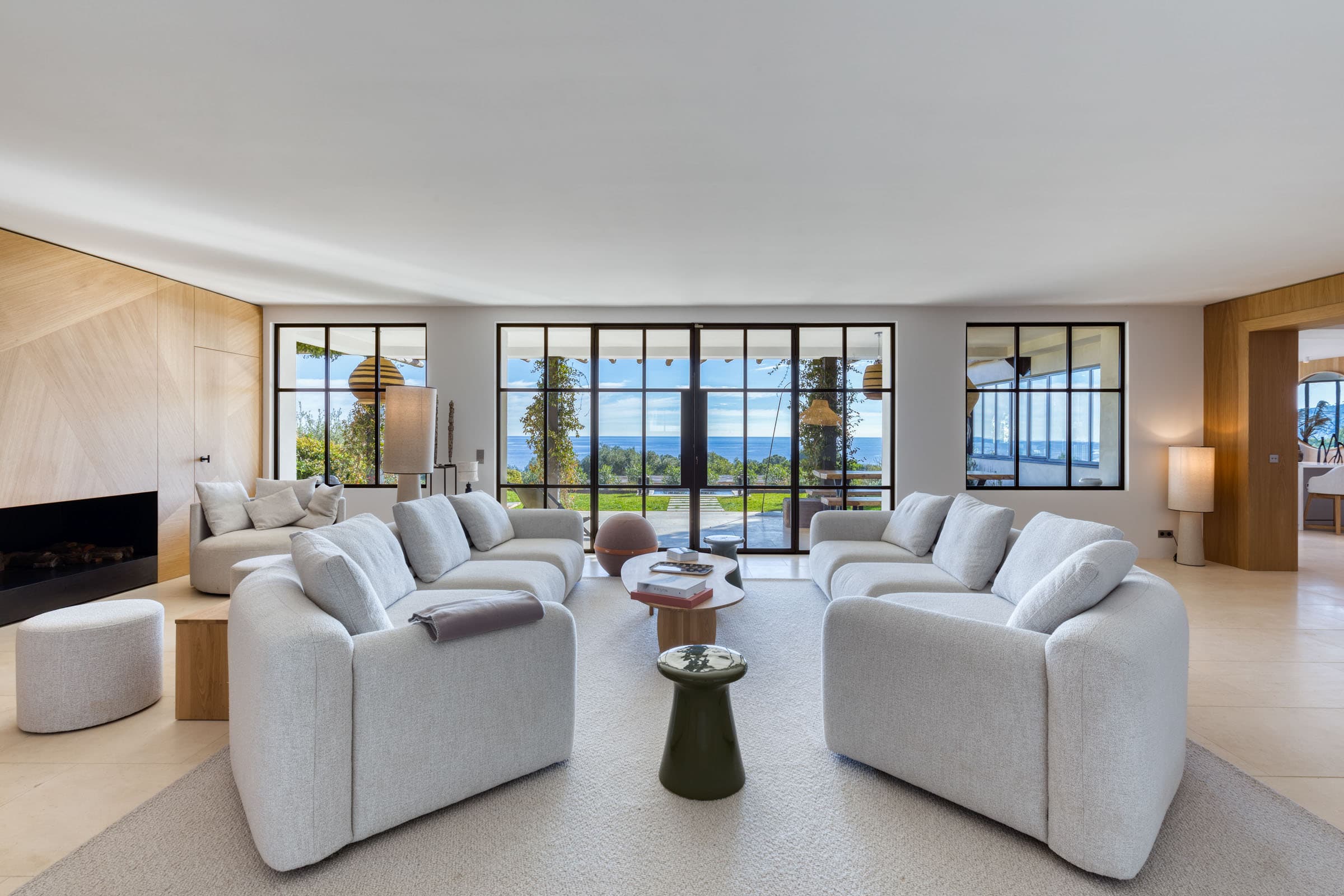 Grand séjour lumineux avec baies vitrées ouvertes sur la mer dans une villa de luxe à vendre au cœur du Golfe de Saint-Tropez.