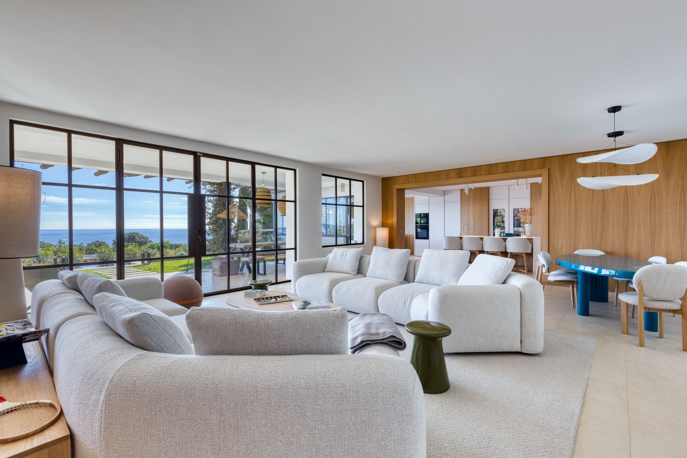 Grand séjour lumineux avec baies vitrées ouvertes sur la mer dans une villa de luxe à vendre au cœur du Golfe de Saint-Tropez.