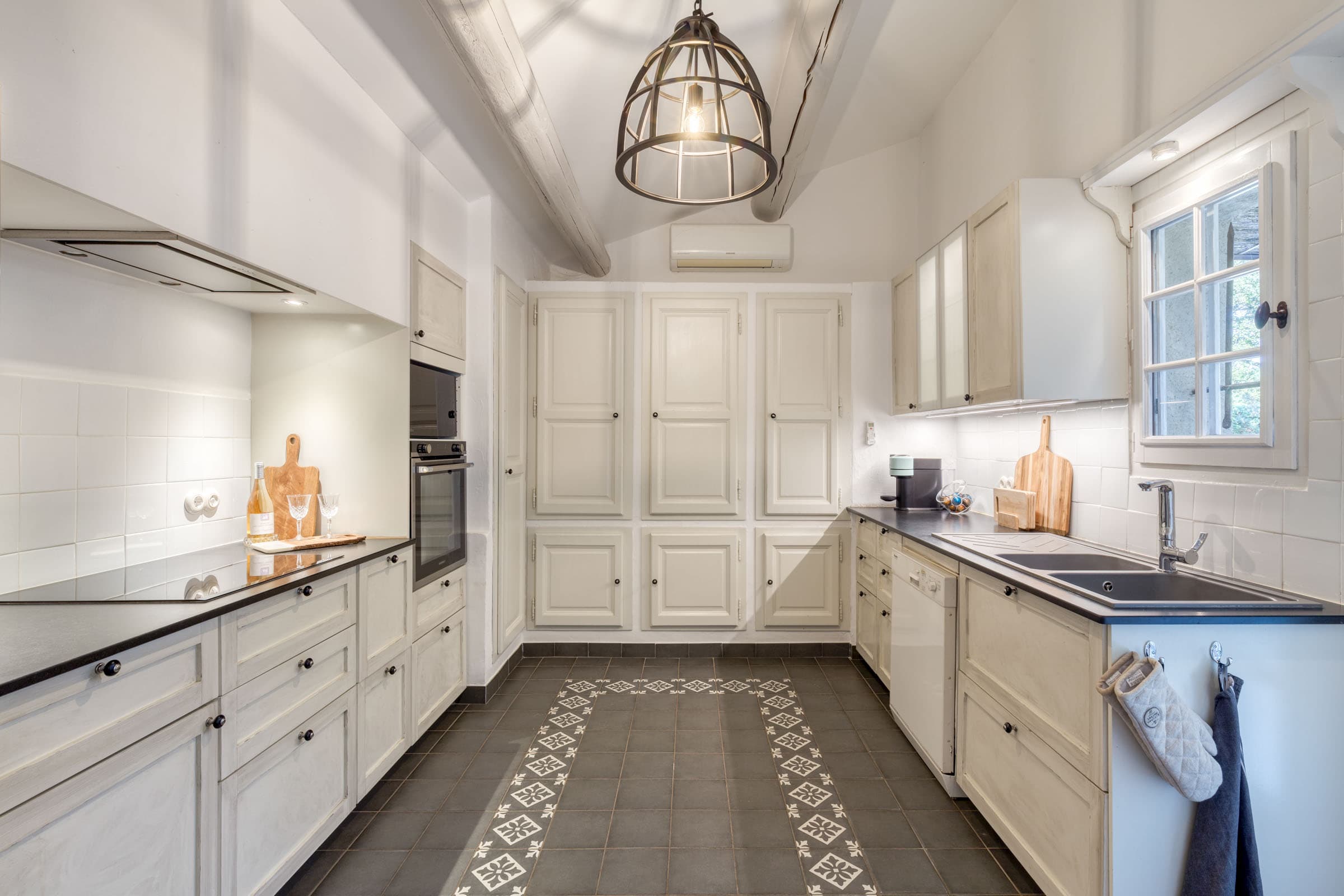 Cuisine entièrement équipée d’une villa à vendre à Maubec, bastide charmante avec terrasse arrière pour repas en plein air, piscine et 4 chambres.