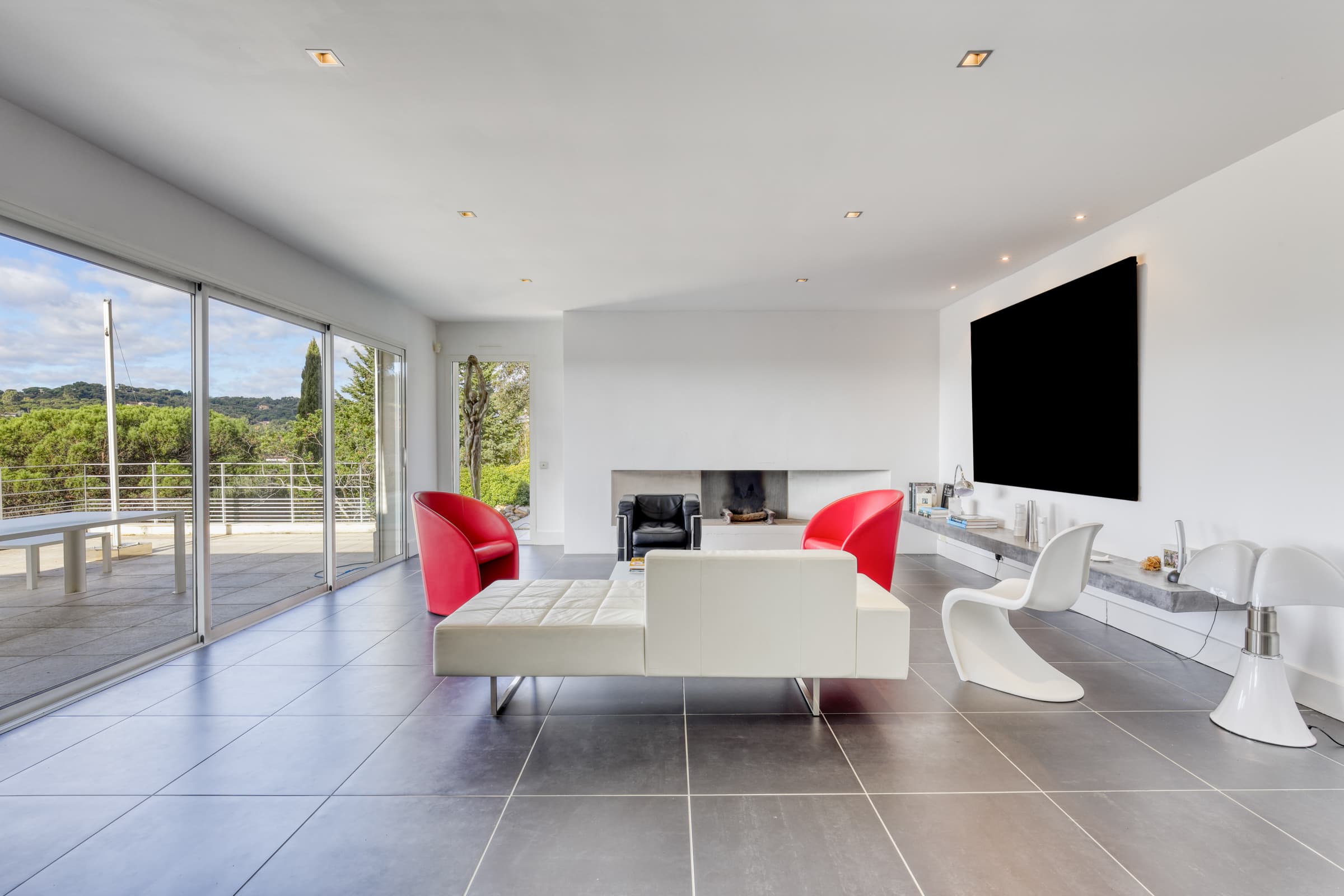 Séjour lumineux avec cheminée pour cette villa à vendre à Gigaro, ouvert sur terrasse et vue mer.