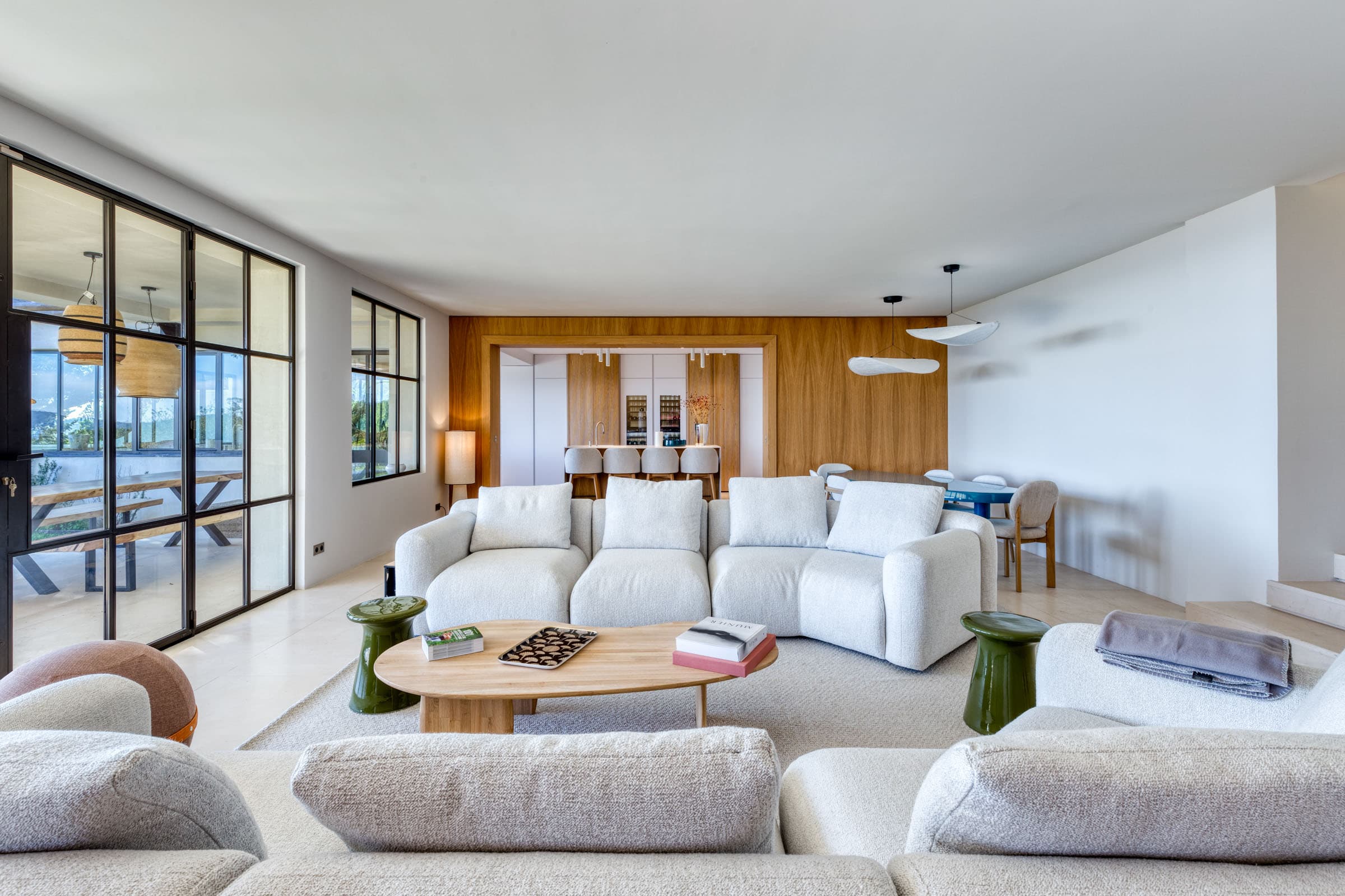 Grand séjour lumineux avec baies vitrées ouvertes sur la mer dans une villa de luxe à vendre au cœur du Golfe de Saint-Tropez.
