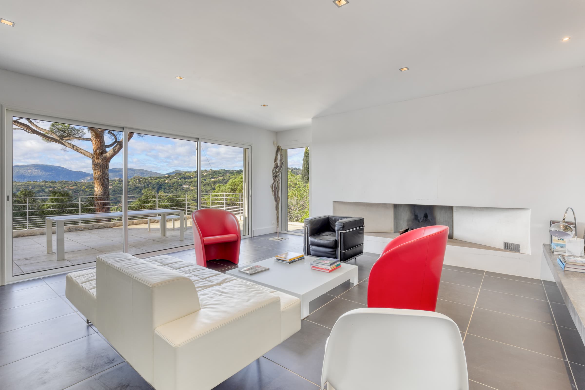 Séjour lumineux avec cheminée pour cette villa à vendre à Gigaro, ouvert sur terrasse et vue mer.