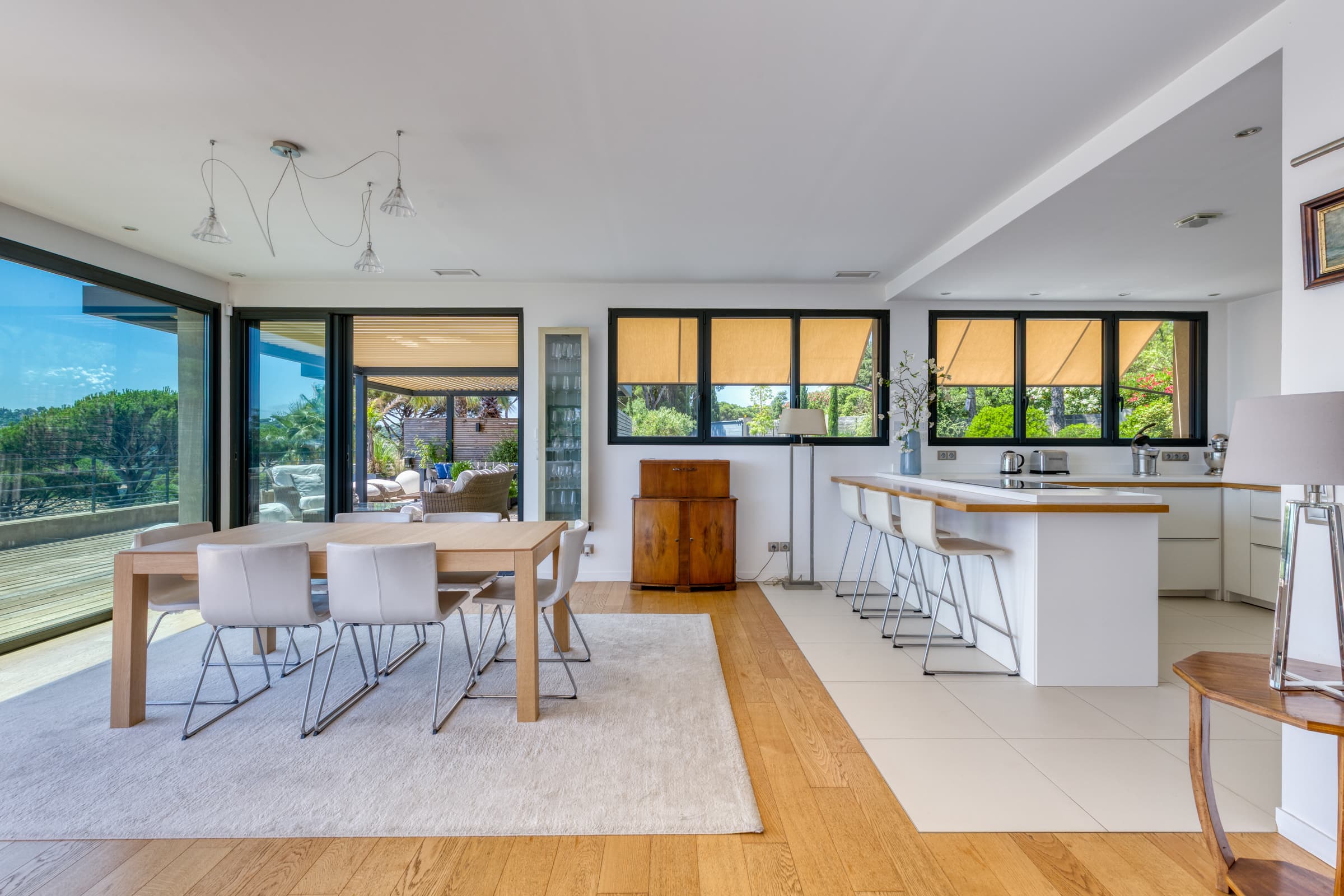 Espace repas raffiné avec grandes baies vitrées offrant une vue mer panoramique exceptionnelle sur Sainte-Maxime.