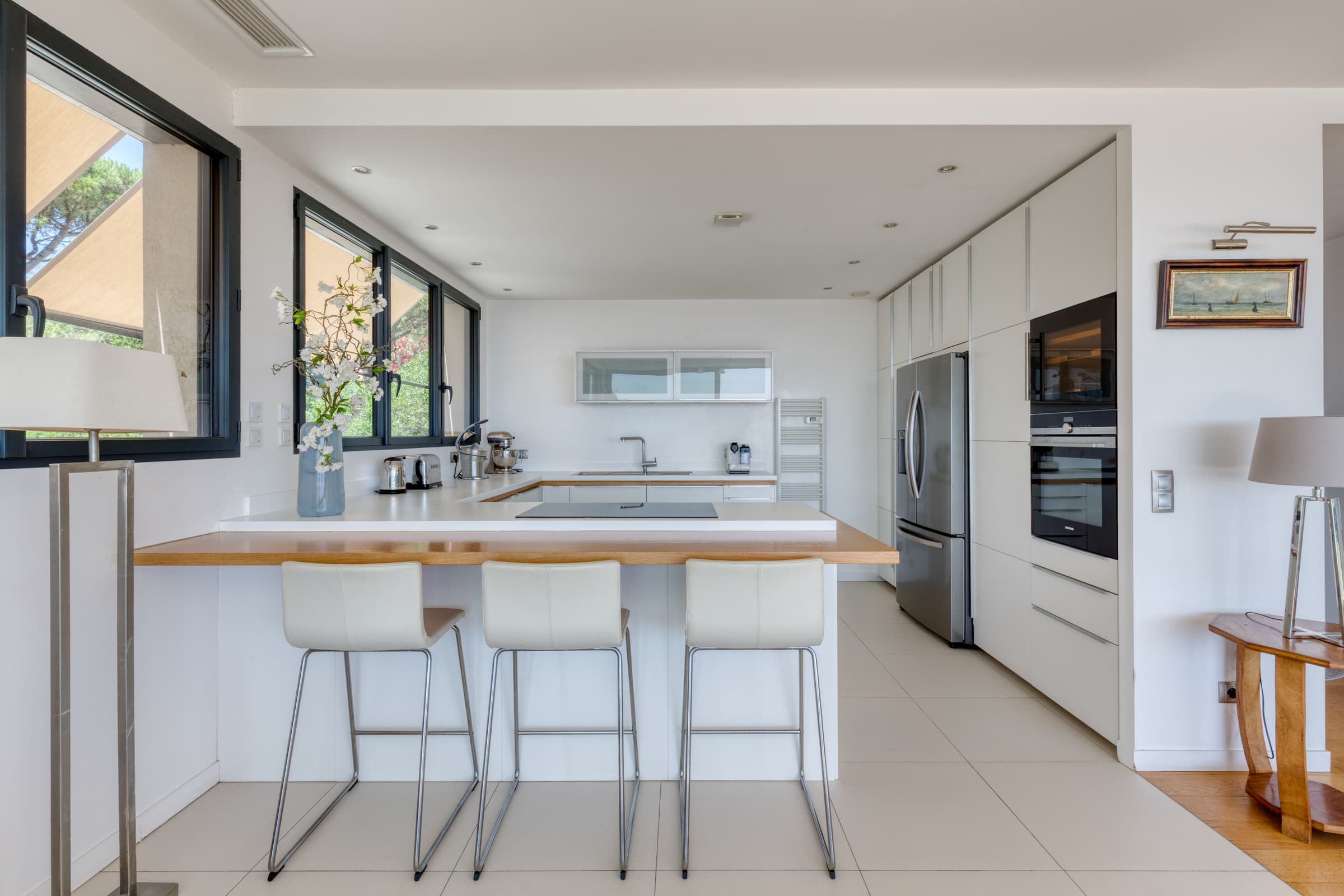 Cuisine moderne et lumineuse dans villa à vendre à Sainte-Maxime, ouverte sur la terrasse et la mer Méditerranée.