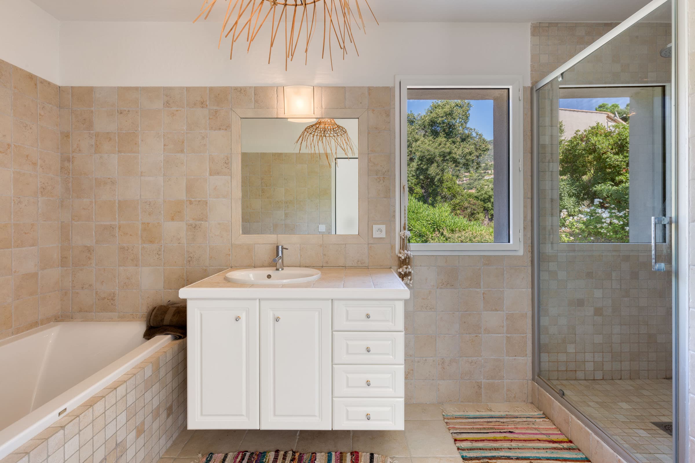 Salle de bain moderne avec douche et baignoire, finitions de qualité, villa récente à Cavalaire-sur-Mer.