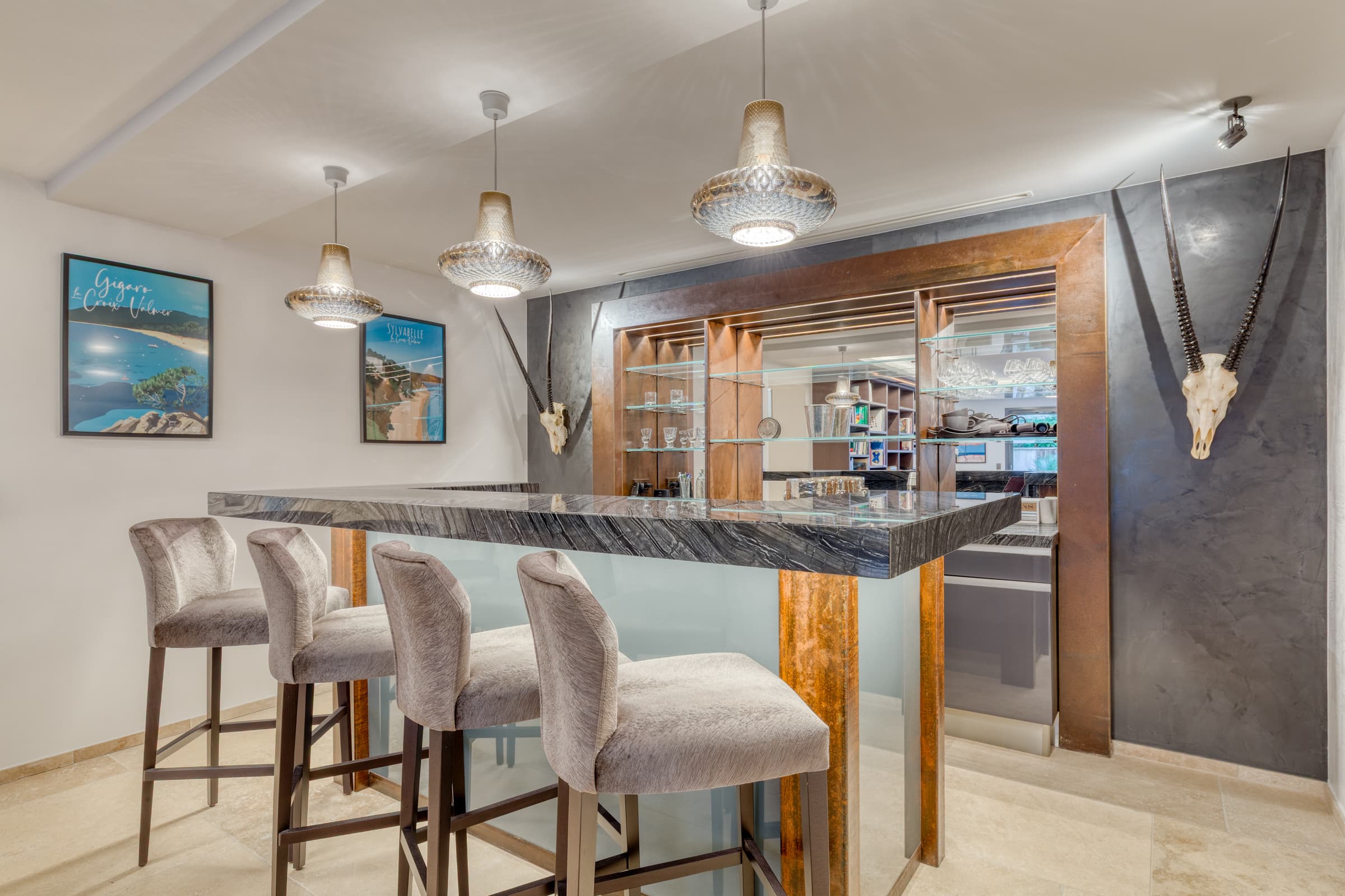 Salon-bar cosy donnant sur patio tropical. Ambiance raffinée et conviviale dans une villa de luxe à Gigaro.