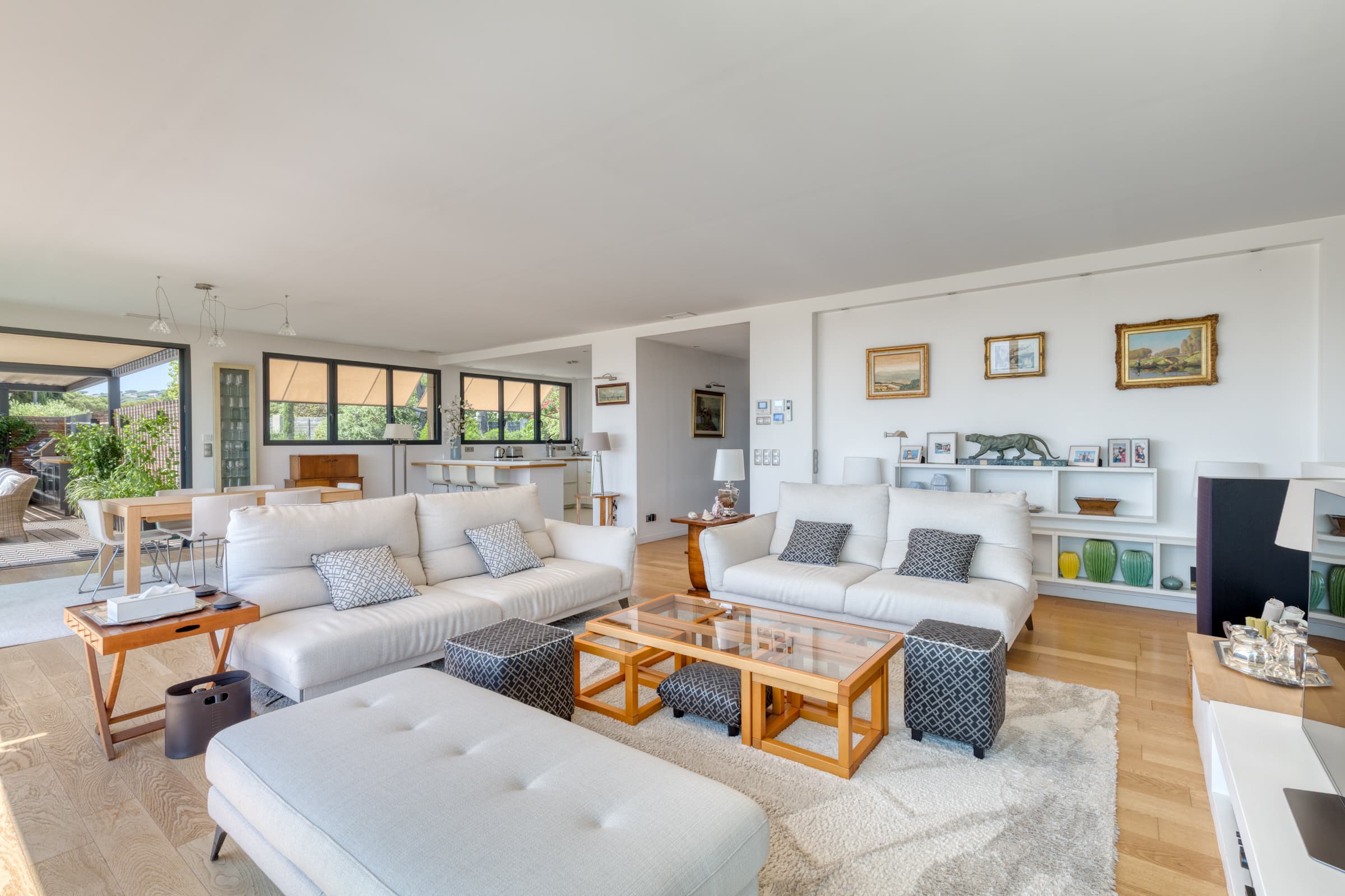 Pièce de vie spacieuse et élégante dans villa contemporaine à Sainte-Maxime, ouverte sur la terrasse avec vue panoramique sur la mer.