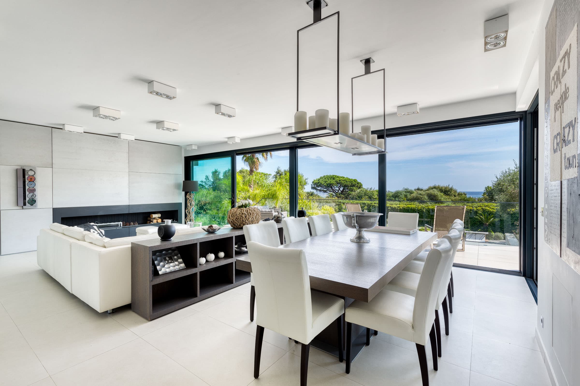 Salle à manger contemporaine ouverte sur la terrasse, dans une villa de luxe à vendre à Ramatuelle Pampelonne.