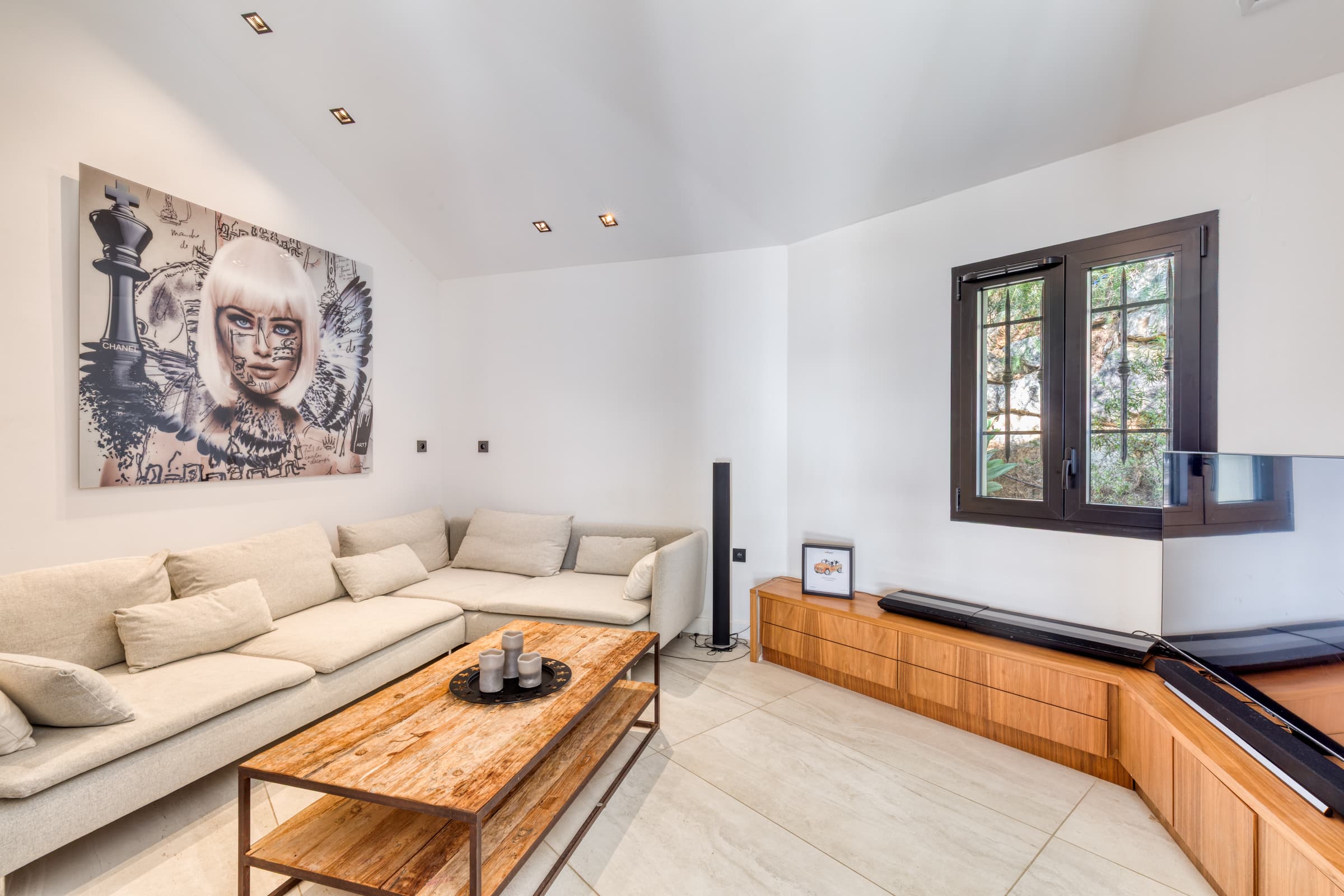 Salon lumineux de la villa à vendre, grande baie vitrée avec vue imprenable sur la mer et les pins parasols.