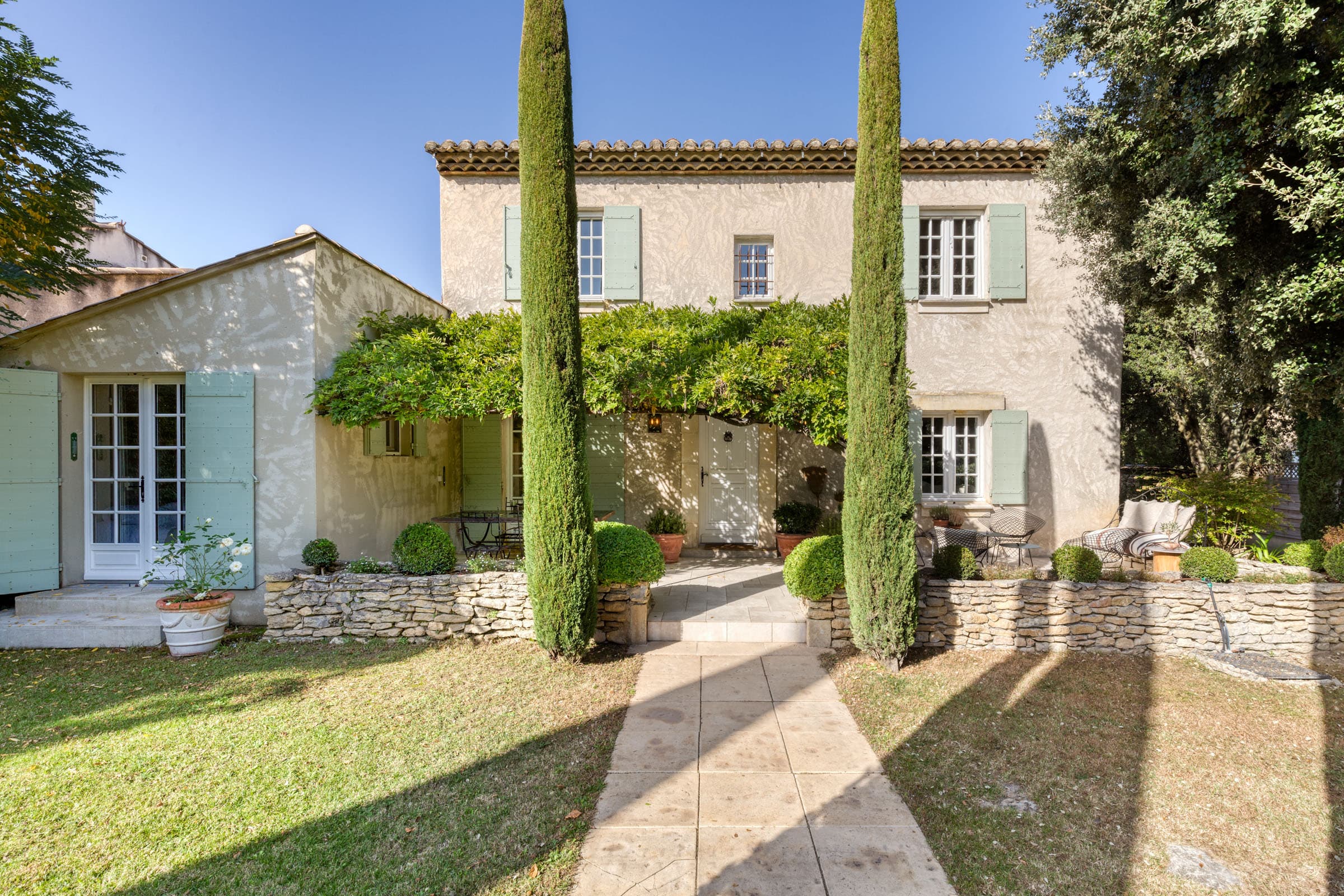 Façade d'une villa à vendre à Maubec, bastide charmante avec jardin paysager, terrasse ensoleillée et piscine, 4 chambres, parfait état.