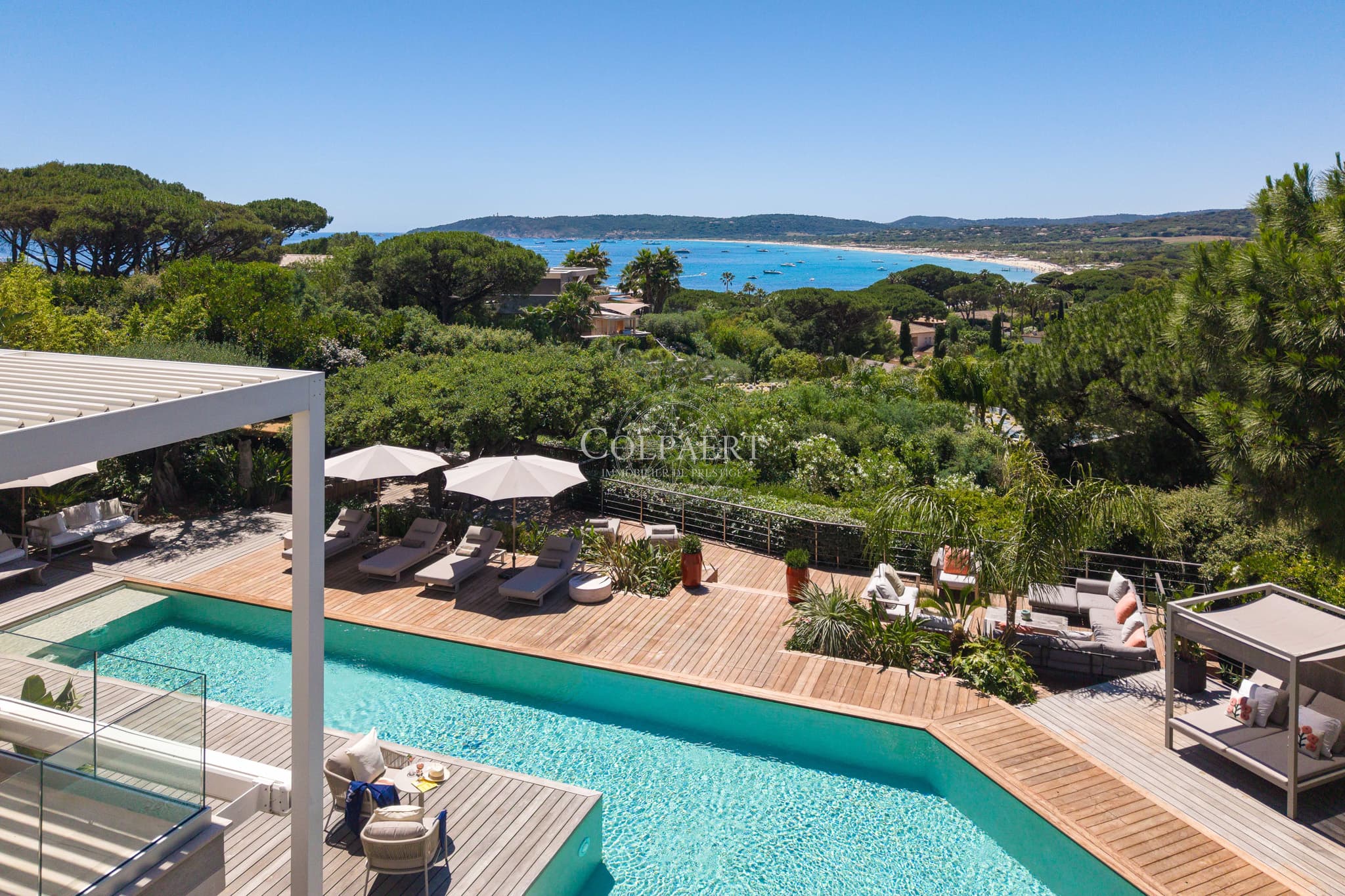 Grande terrasse ensoleillée offrant une vue spectaculaire sur la Méditerranée et les jardins paysagers.