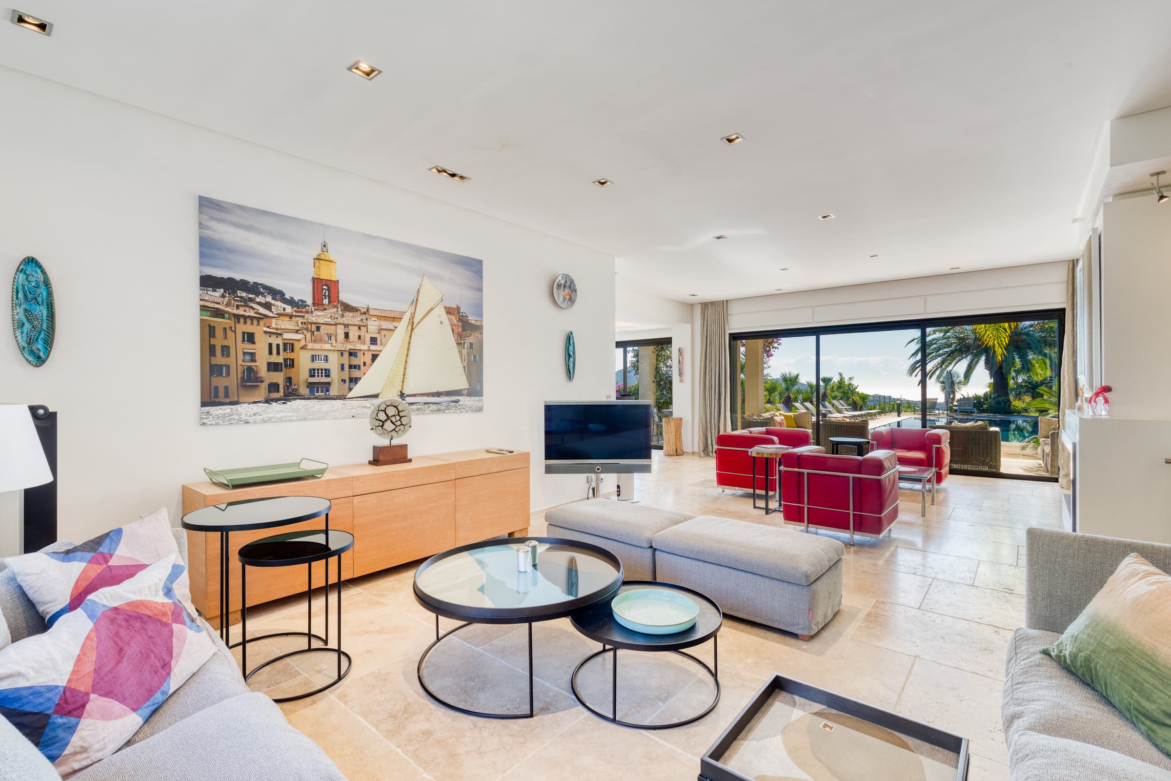 Grand salon avec cheminée et baies vitrées ouvrant sur la terrasse. Villa de prestige à vendre à La Croix-Valmer.