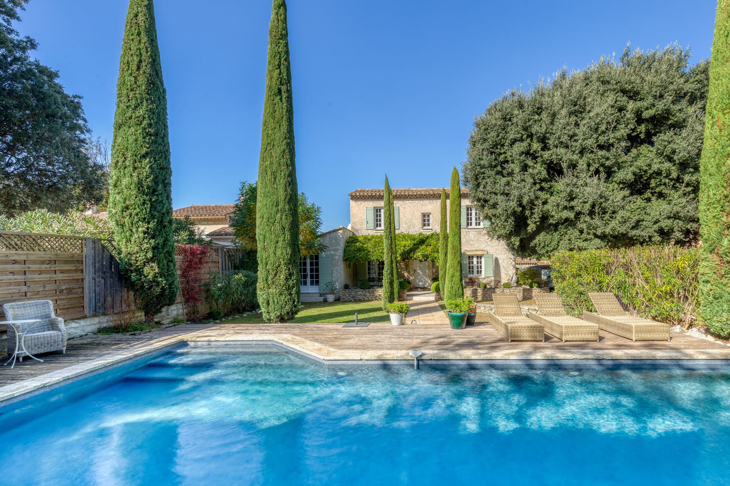 Façade d'une villa à vendre à Maubec, bastide charmante avec jardin paysager, terrasse ensoleillée et piscine, 4 chambres, parfait état.