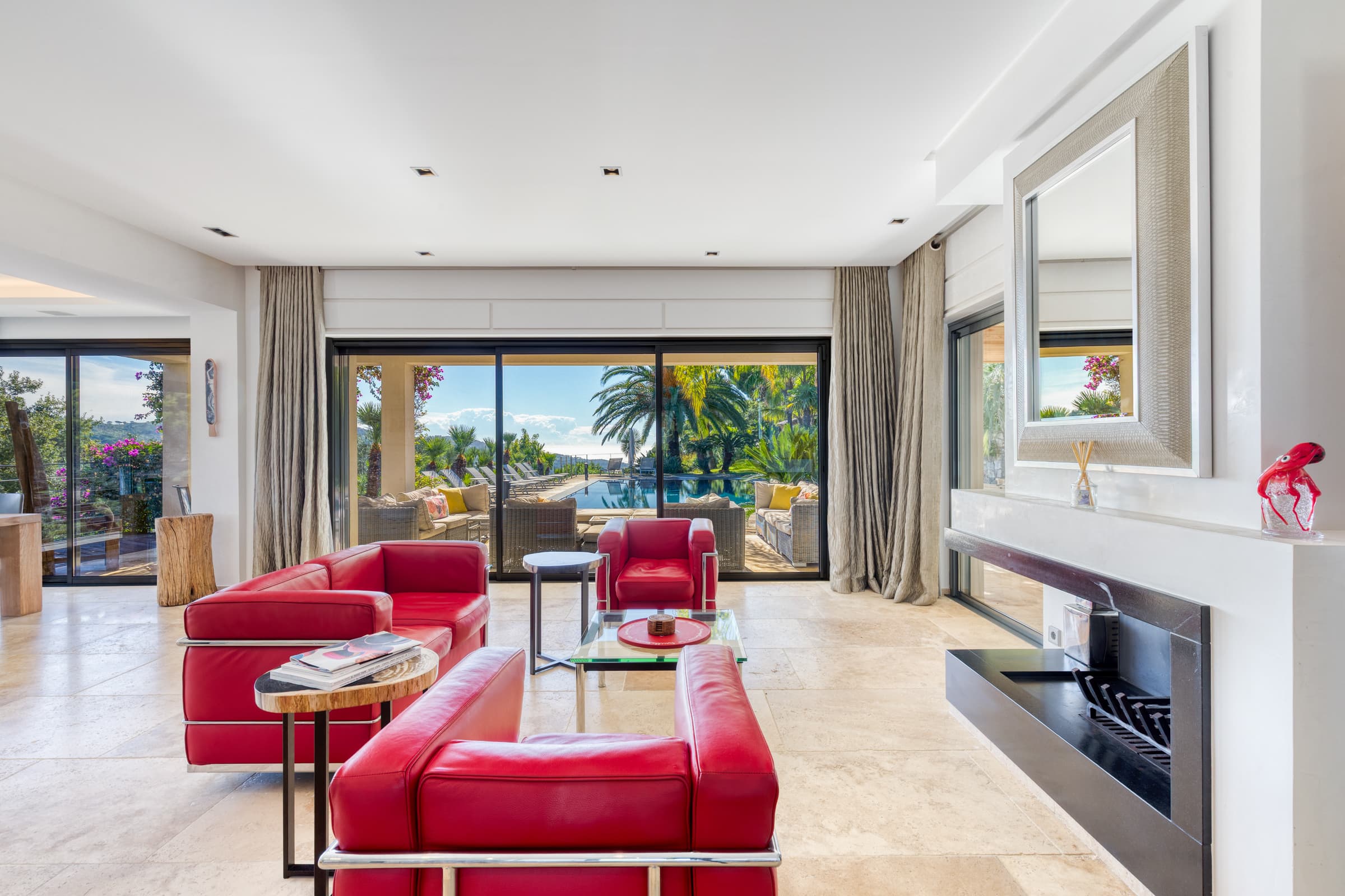 Grand salon avec cheminée et baies vitrées ouvrant sur la terrasse. Villa de prestige à vendre à La Croix-Valmer.
