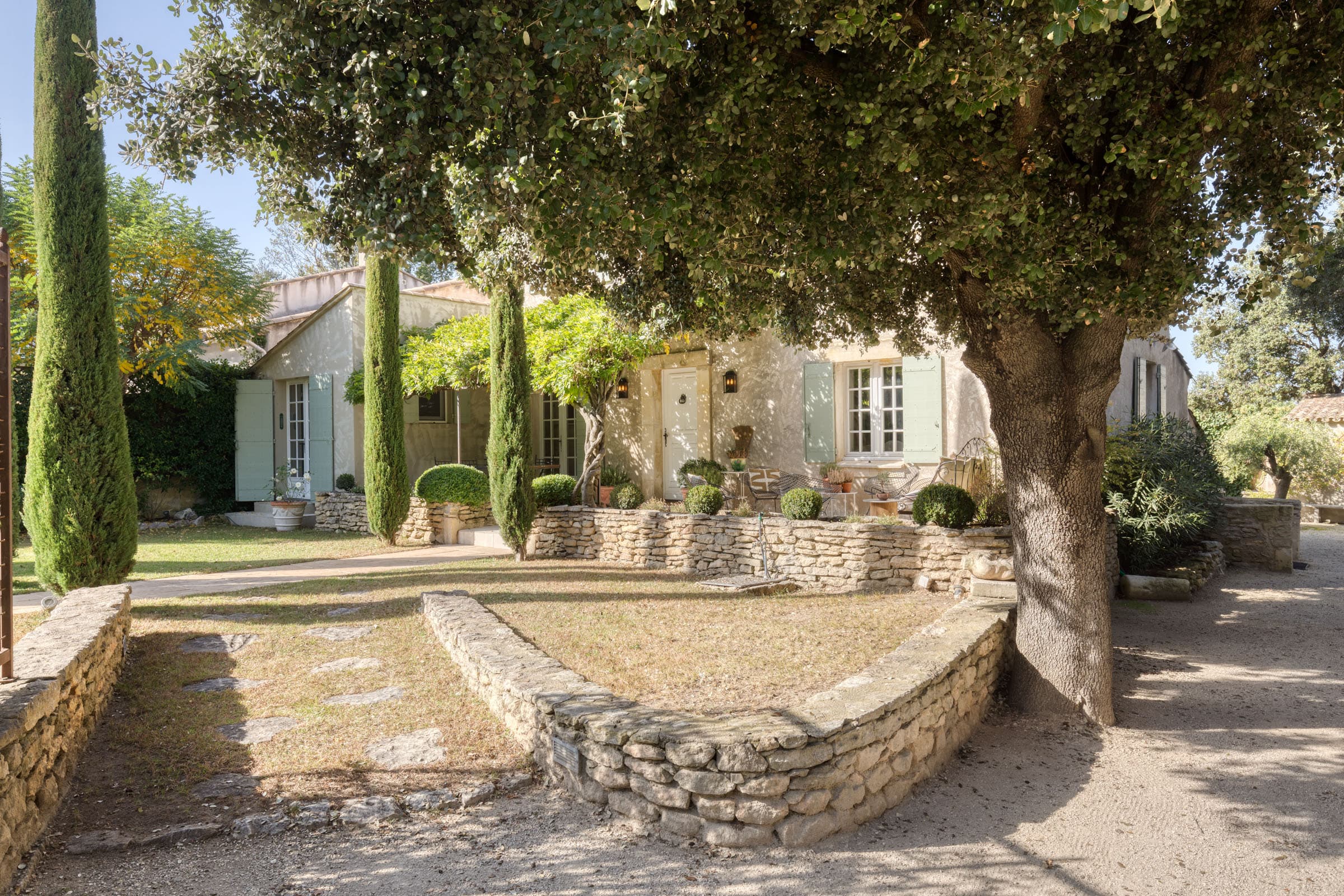 Façade d'une villa à vendre à Maubec, bastide charmante avec jardin paysager, terrasse ensoleillée et piscine, 4 chambres, parfait état.
