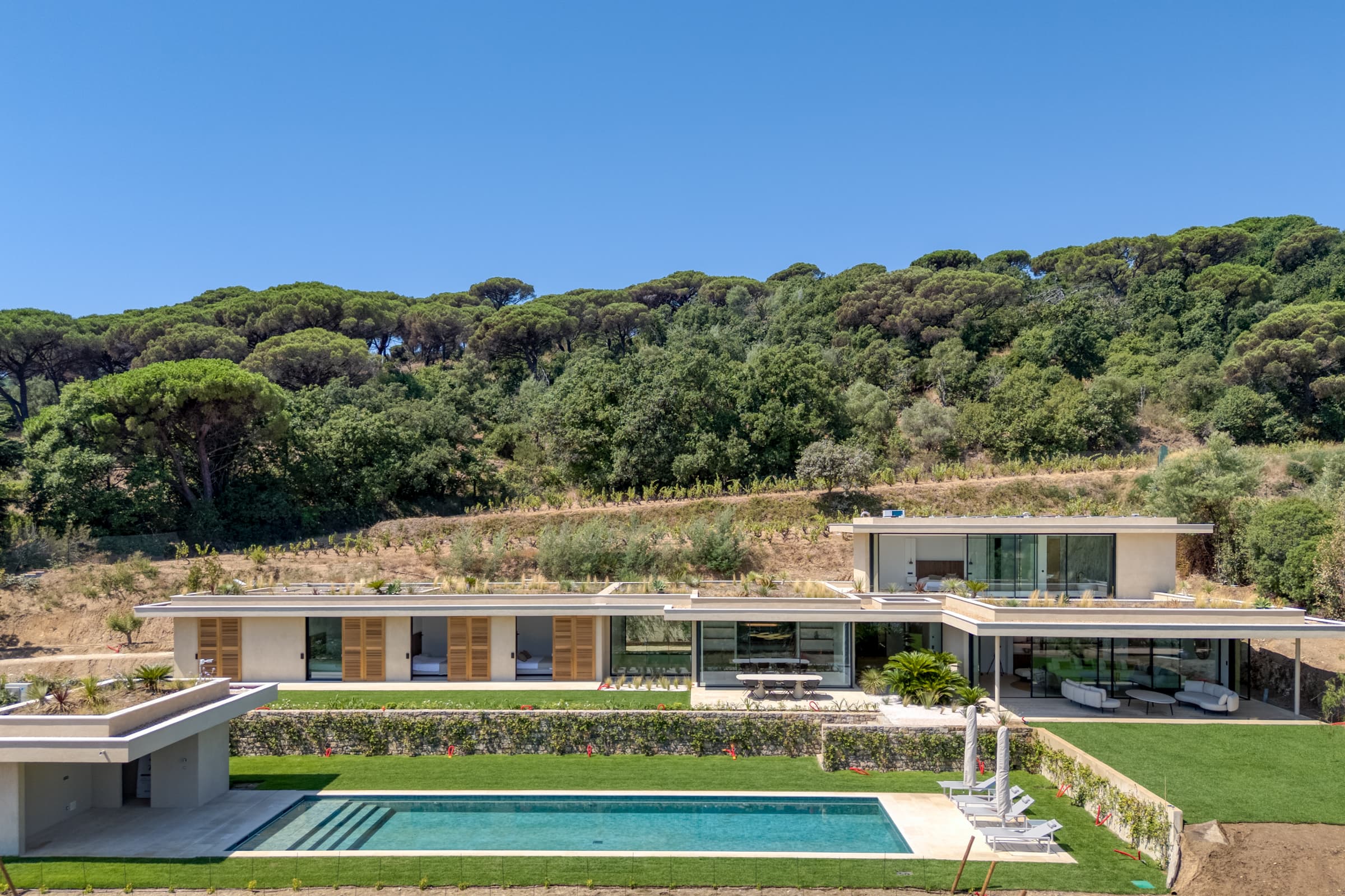 Villa de luxe à vendre à Ramatuelle, Pampelonne : façade élégante et jardin paysager avec vue mer.