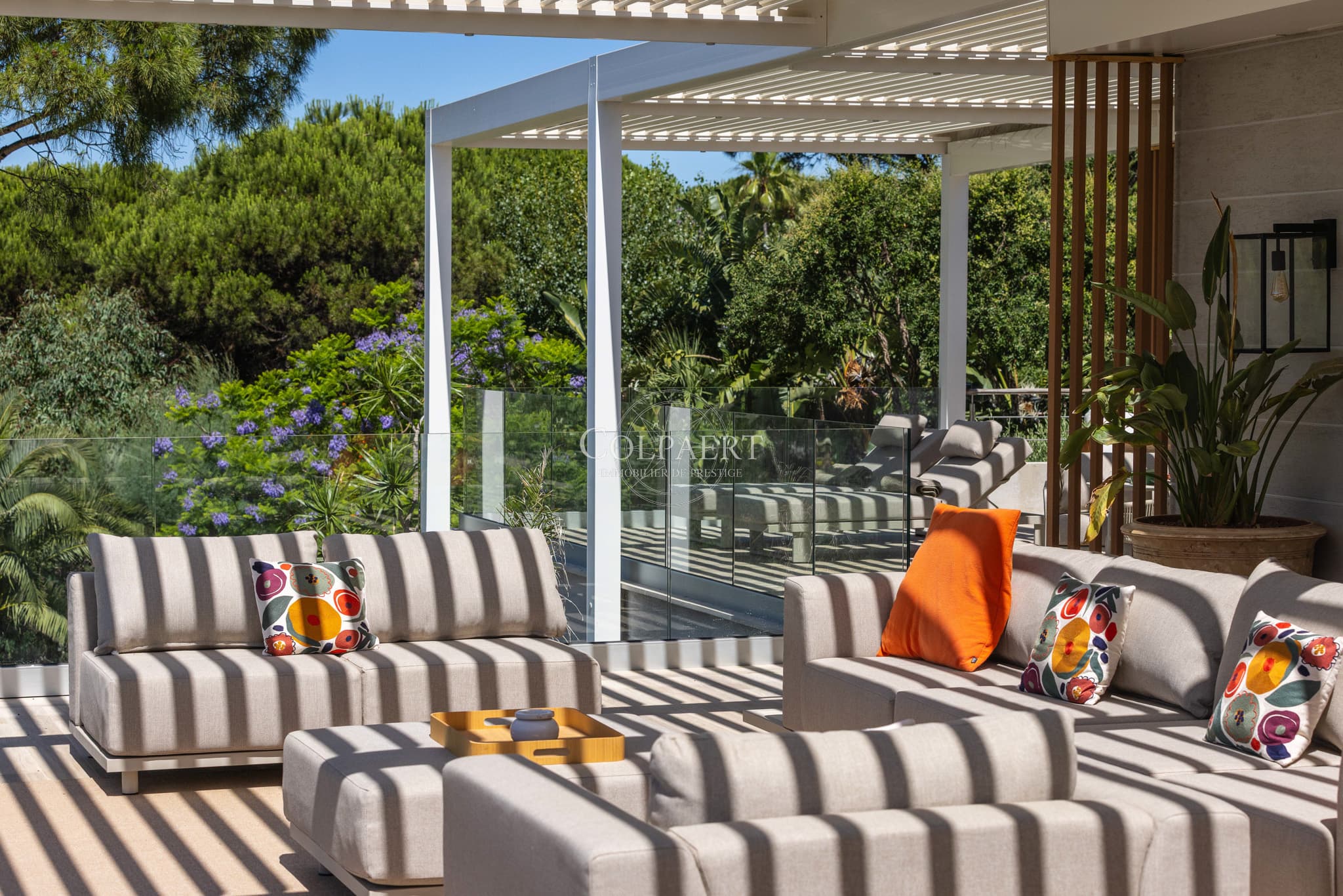 Grande terrasse ensoleillée offrant une vue spectaculaire sur la Méditerranée et les jardins paysagers.
