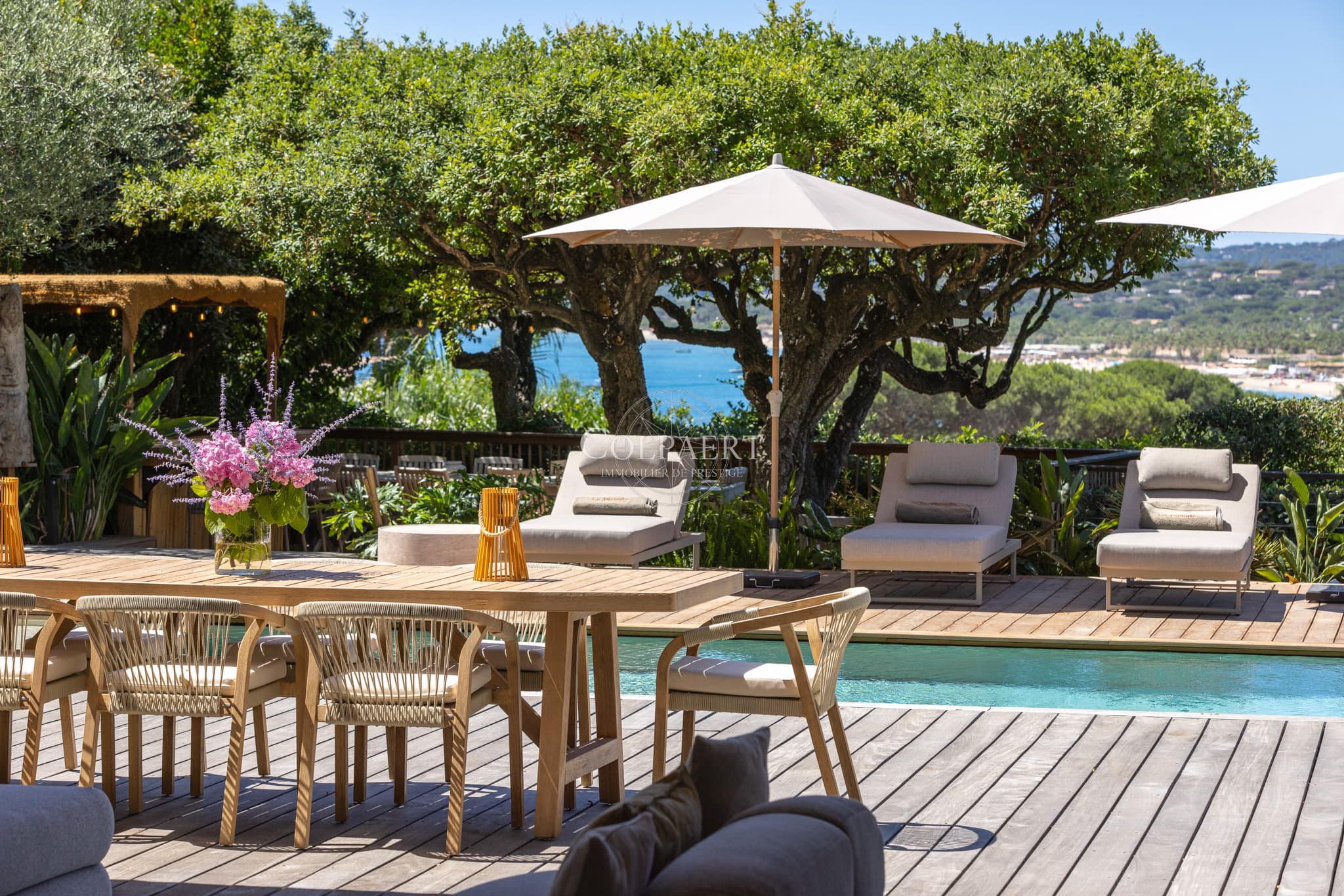 Grande terrasse ensoleillée offrant une vue spectaculaire sur la Méditerranée et les jardins paysagers.