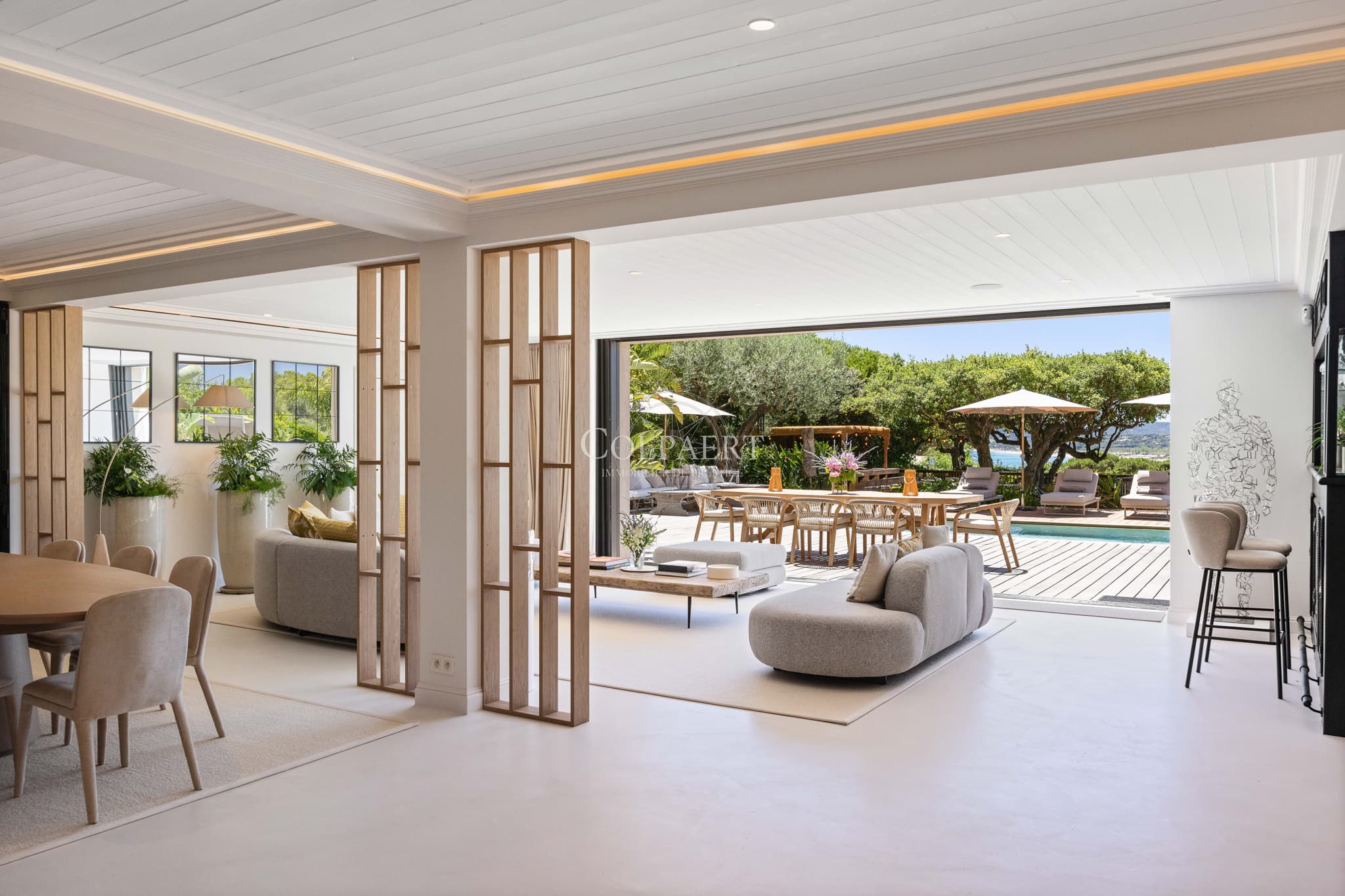 Salon baigné de lumière offrant une vue panoramique sur la Méditerranée dans une propriété de prestige à vendre.