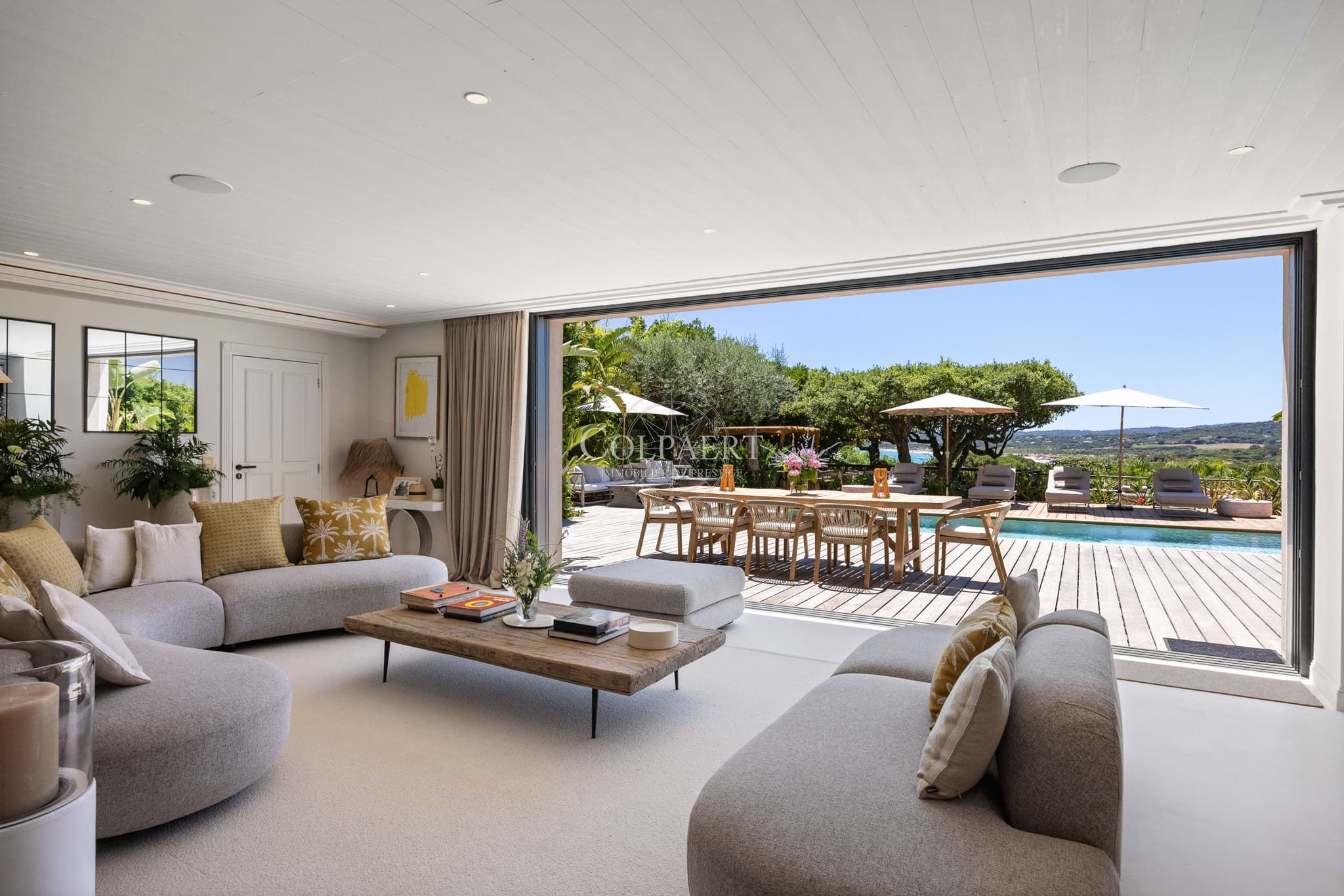 Salon baigné de lumière offrant une vue panoramique sur la Méditerranée dans une propriété de prestige à vendre.