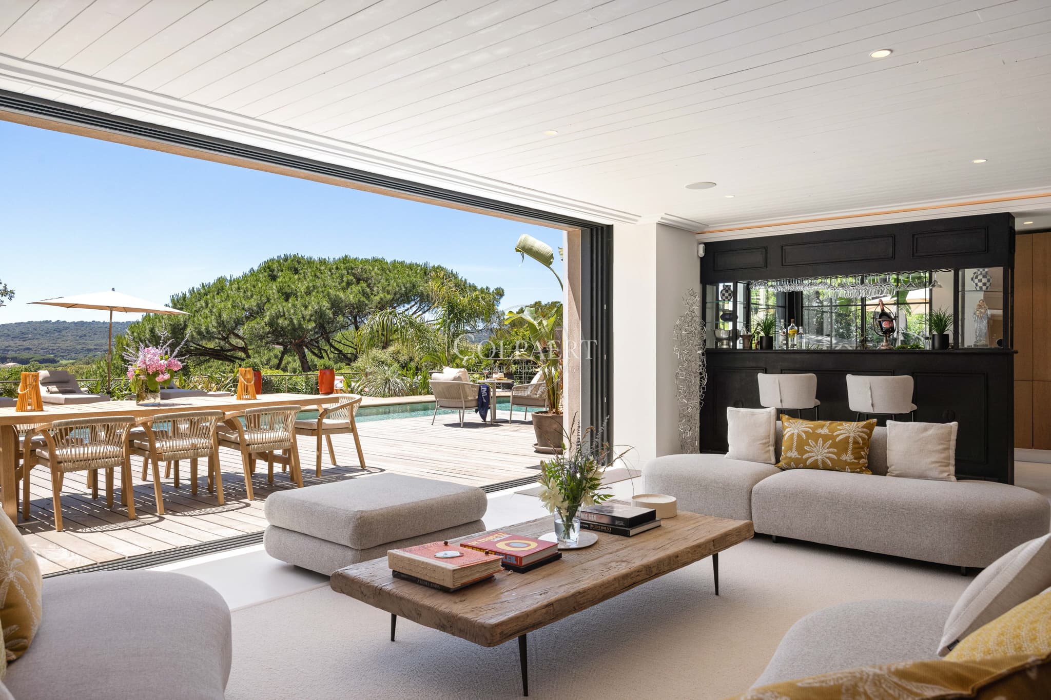 Salon baigné de lumière offrant une vue panoramique sur la Méditerranée dans une propriété de prestige à vendre.