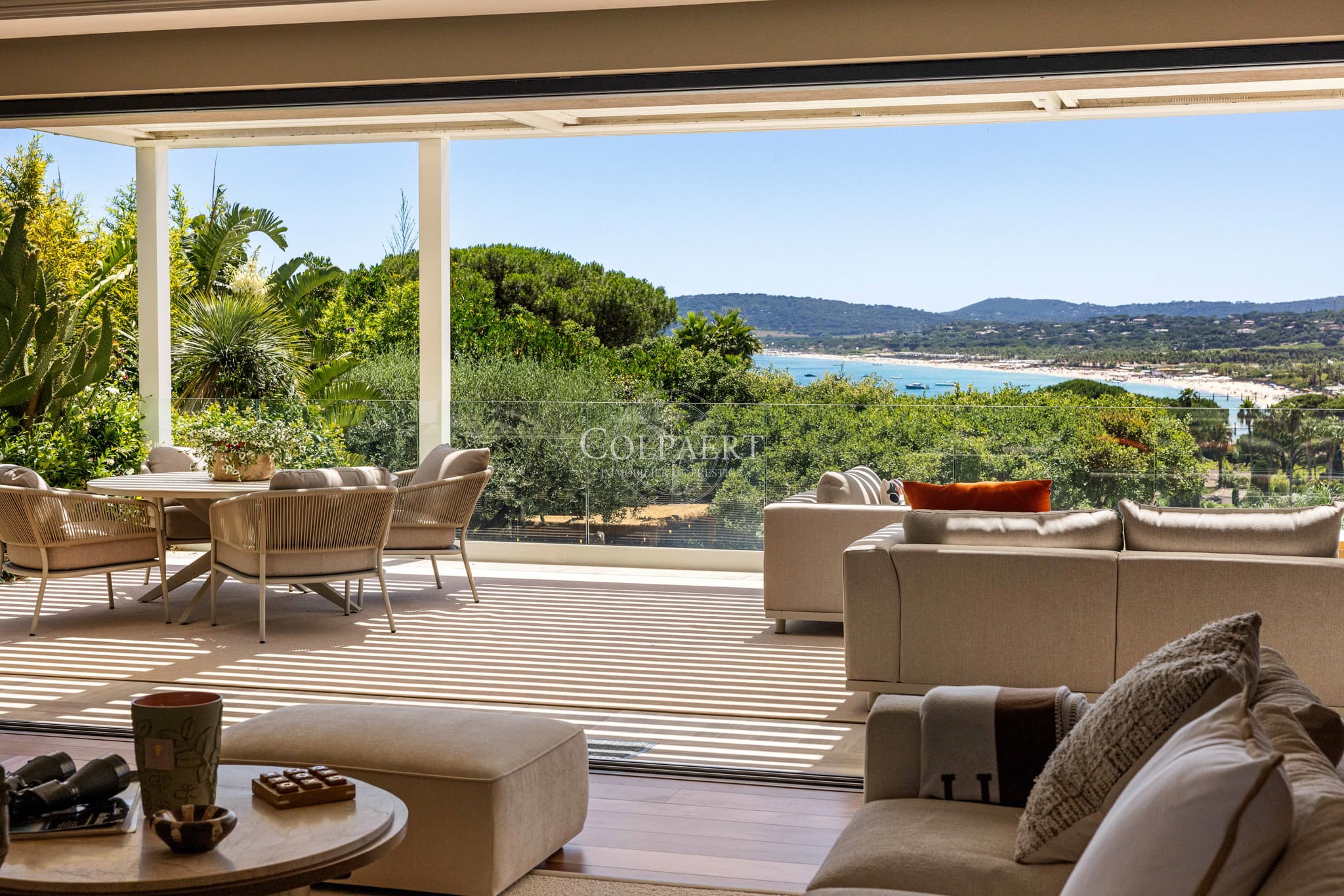 Grande terrasse ensoleillée offrant une vue spectaculaire sur la Méditerranée et les jardins paysagers.
