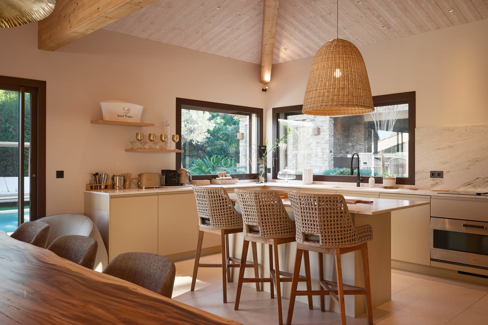 Cuisine haut de gamme entièrement équipée avec îlot central dans cette villa de luxe à vendre à Ramatuelle, ouverte sur un vaste espace de réception.