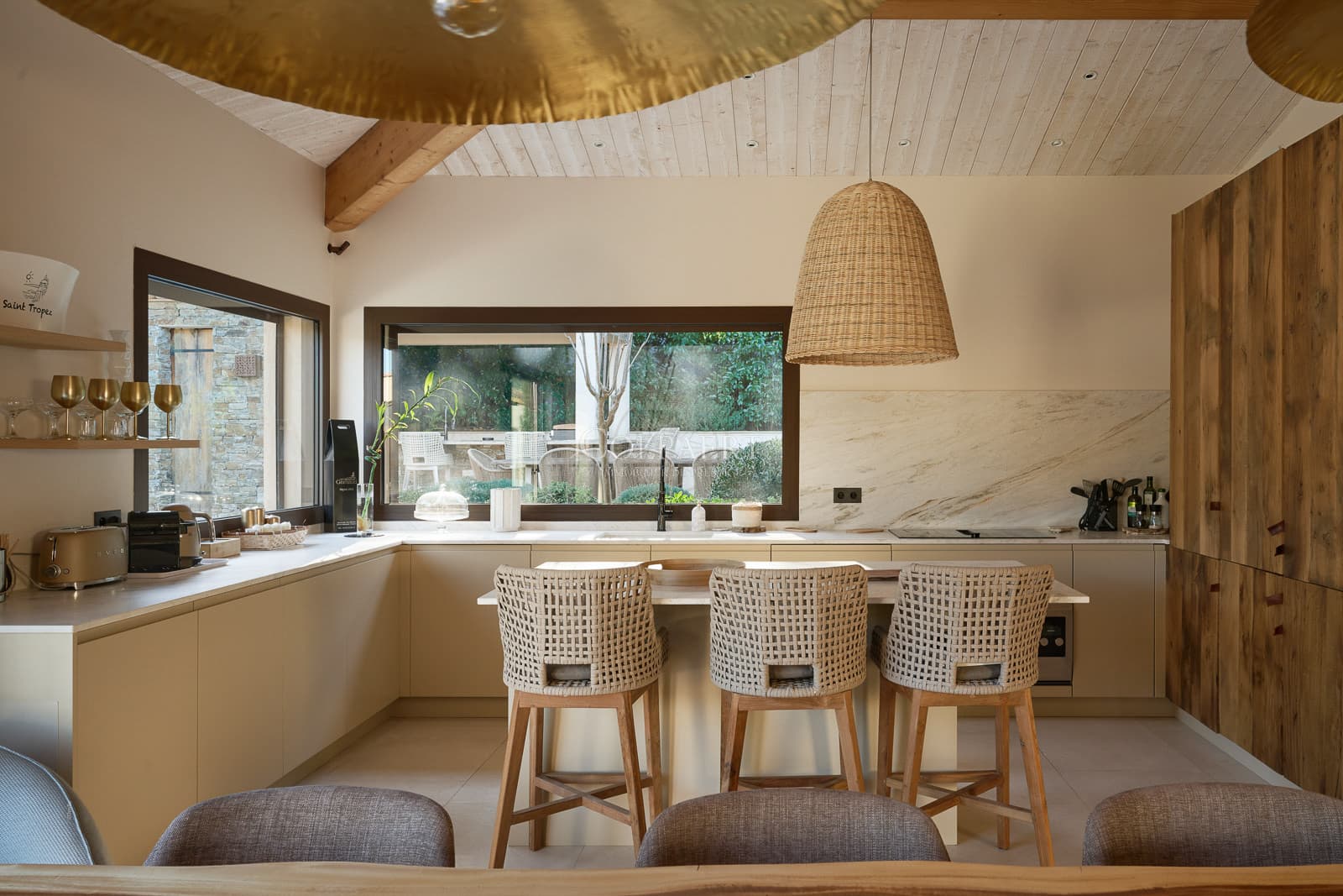 Cuisine haut de gamme entièrement équipée avec îlot central dans cette villa de luxe à vendre à Ramatuelle, ouverte sur un vaste espace de réception.