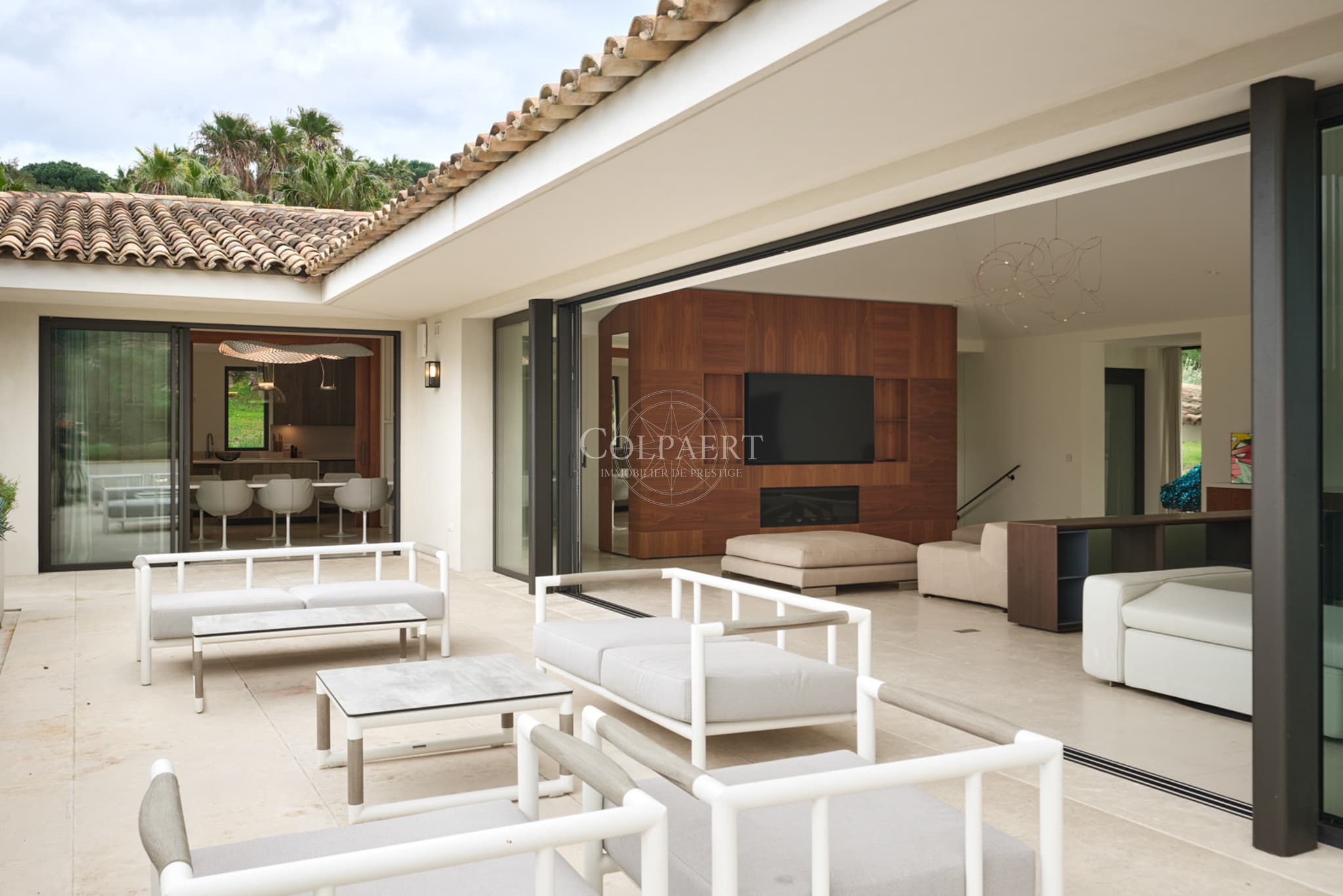 Terrasse spacieuse ouverte sur le jardin et la piscine dans cette villa contemporaine à vendre près de Saint-Tropez et Pampelonne.