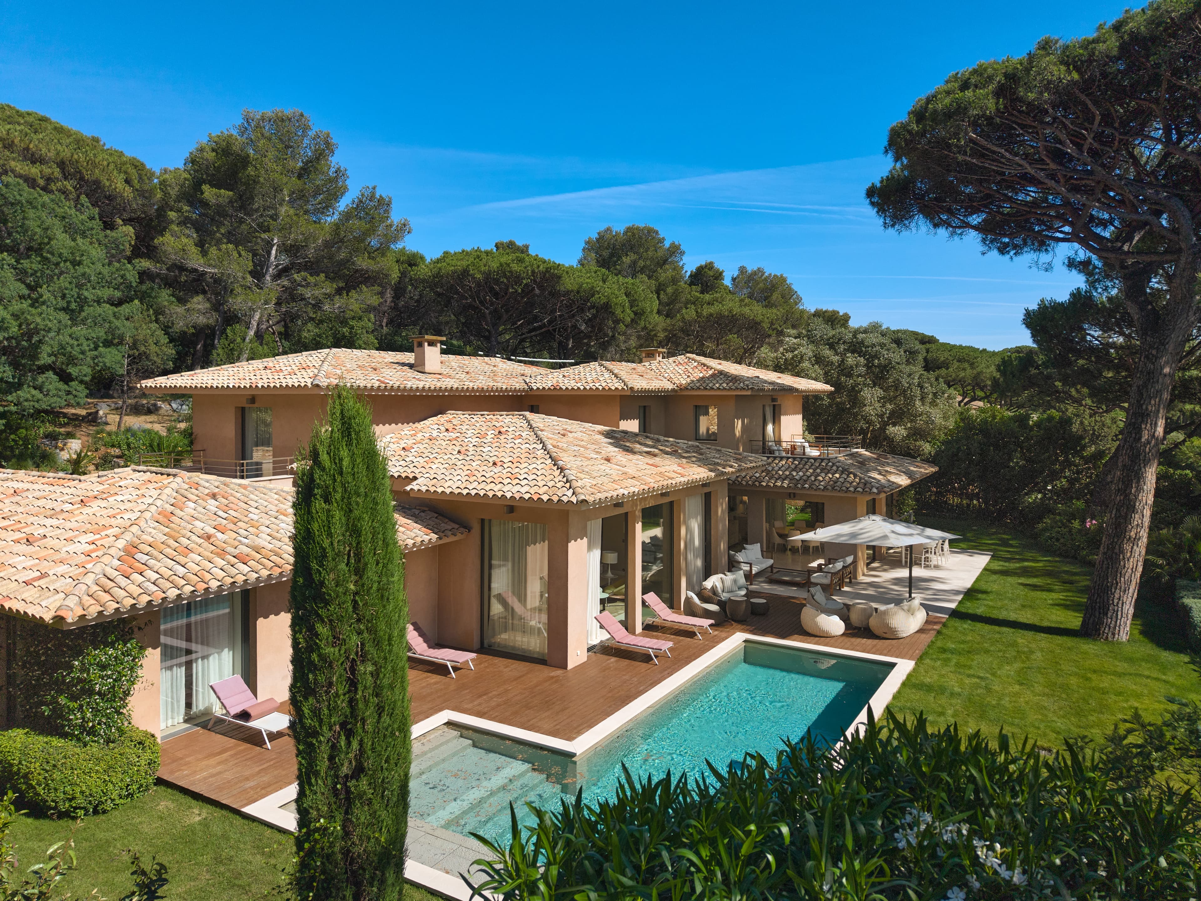 Façade contemporaine d'une villa pieds dans l'eau à vendre dans le prestigieux domaine des Parcs de Saint-Tropez.