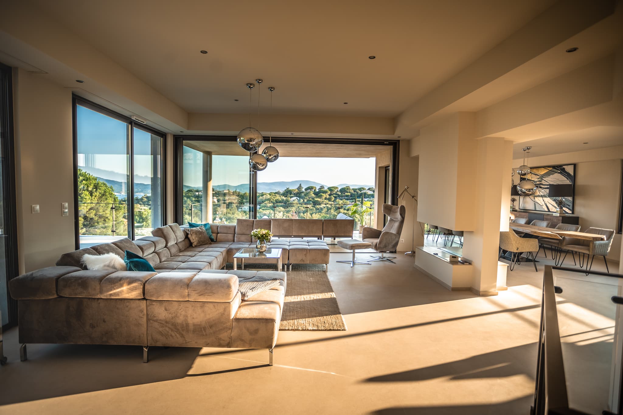 Séjour élégant de la villa avec cheminée et baies vitrées offrant vue panoramique sur le Golfe de Saint-Tropez