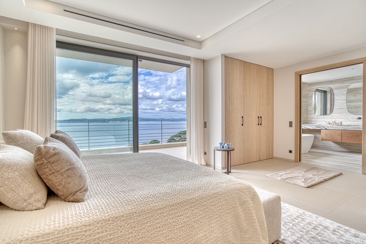 Suite parentale raffinée avec dressing, salle de bain et accès direct à la terrasse avec vue mer panoramique.