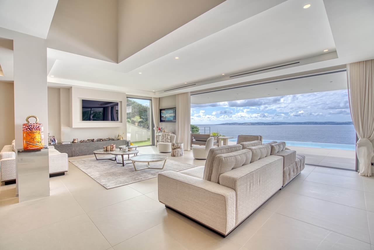 Pièce de vie spacieuse et élégante avec grandes baies vitrées donnant sur la mer, au cœur d’une villa moderne à Sainte-Maxime.