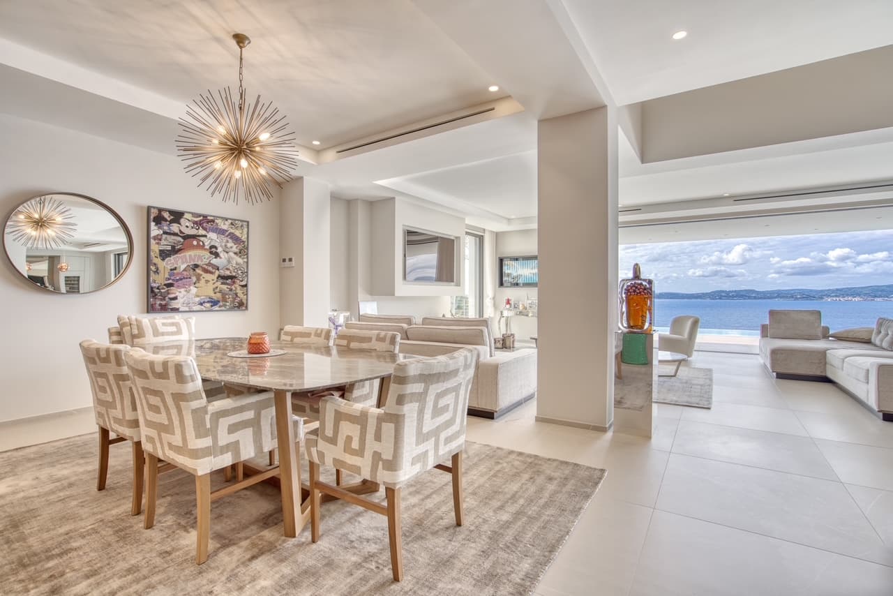 Espace repas convivial ouverte sur la terrasse, dans une villa contemporaine avec vue mer.