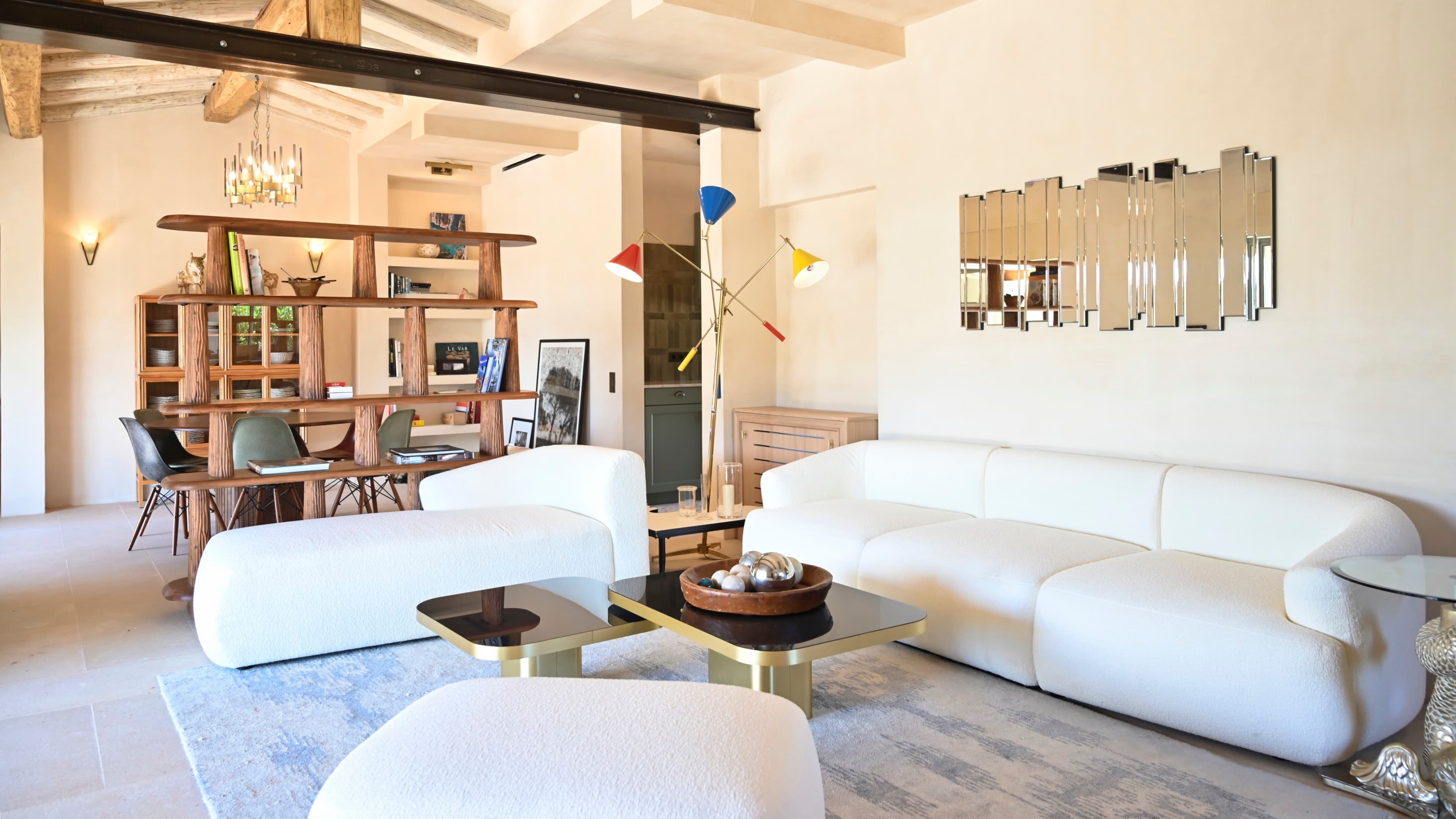 Salon raffiné baigné de lumière naturelle, offrant une ambiance provençale et conviviale à Ramatuelle.