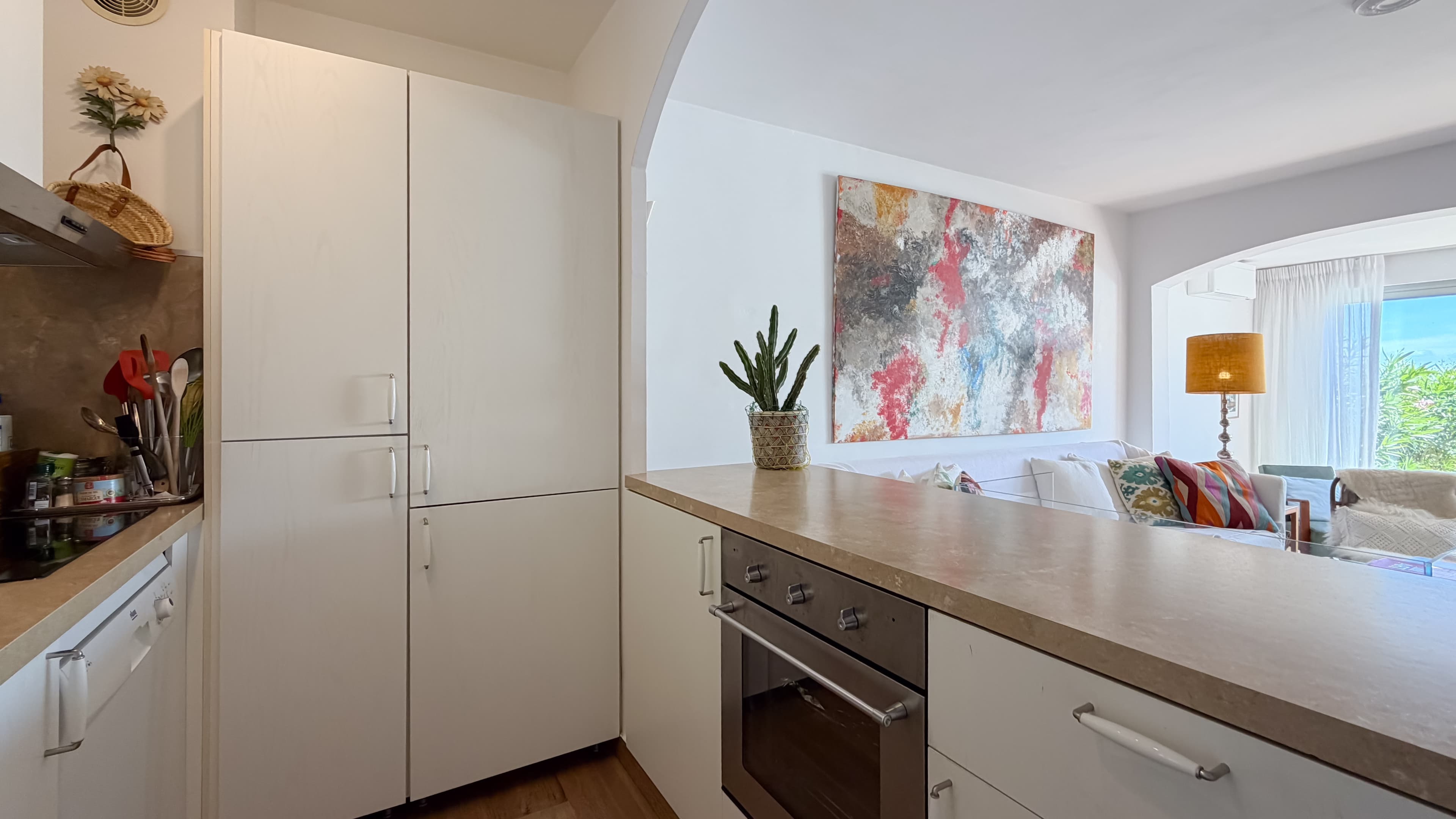 Cuisine ouverte parfaitement intégrée au séjour d’un appartement avec jardin au cœur du Golfe de Saint-Tropez.