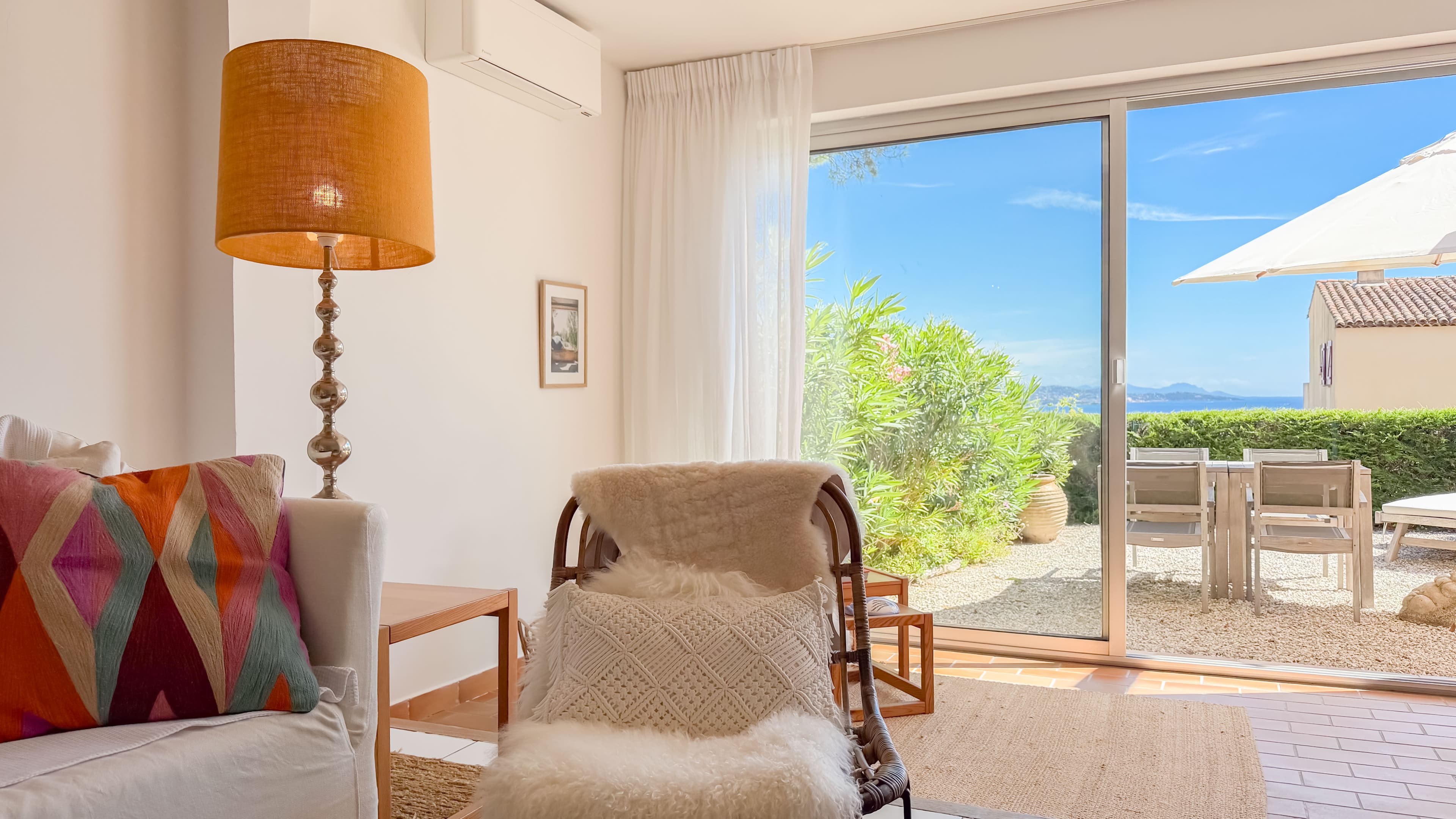 Espace de vie lumineux ouvrant sur la terrasse et le jardin avec vue sur la baie de Saint-Tropez.