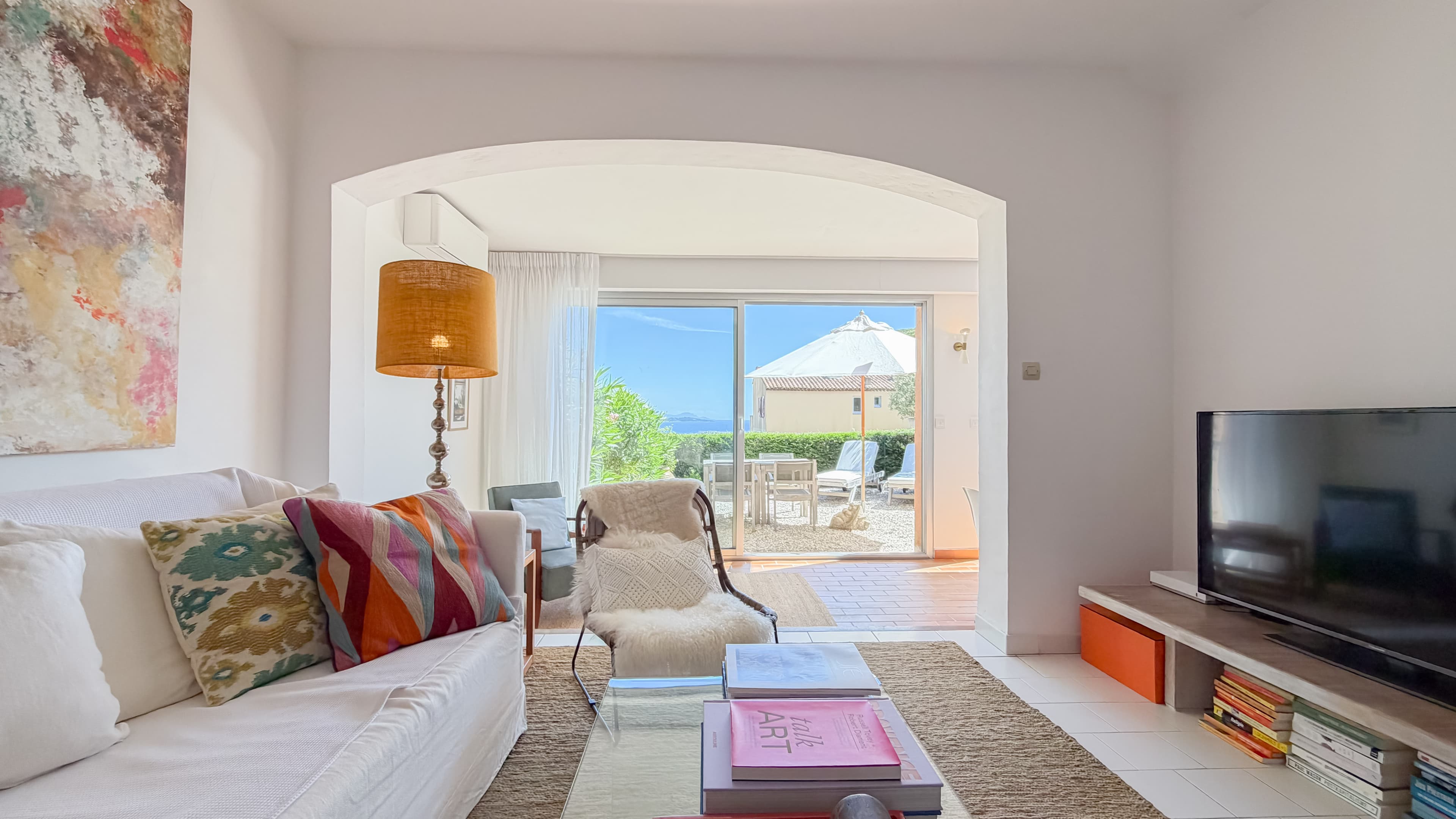 Espace de vie lumineux ouvrant sur la terrasse et le jardin avec vue sur la baie de Saint-Tropez.