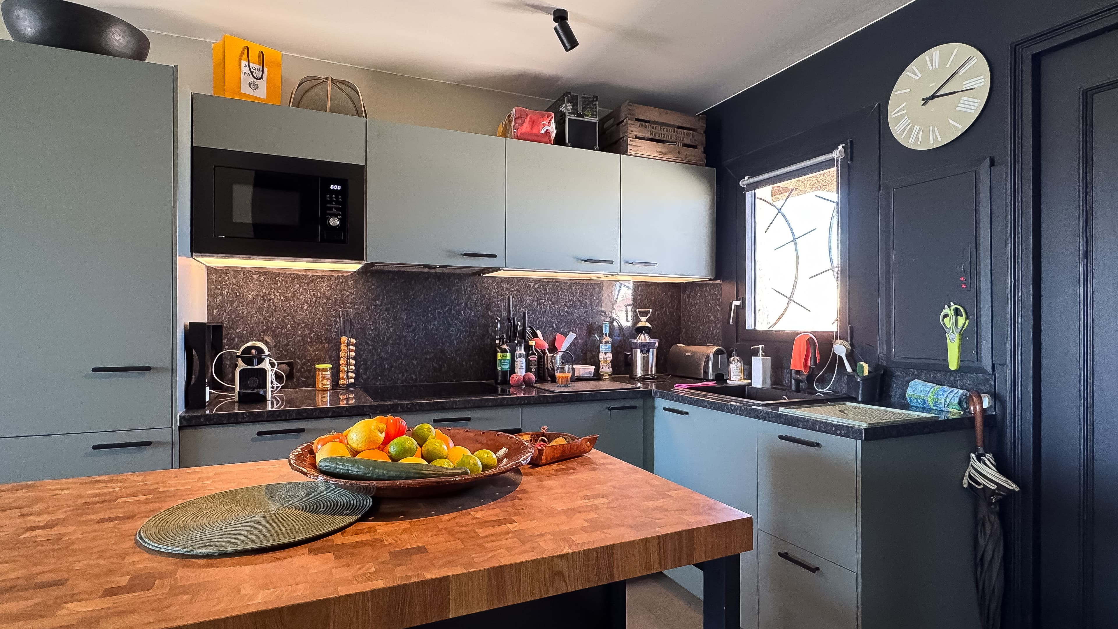 Cuisine entièrement équipée dans un appartement à vendre à Les Marines de Cogolin, ouverte sur le séjour et offrant une vue sur le port de plaisance.