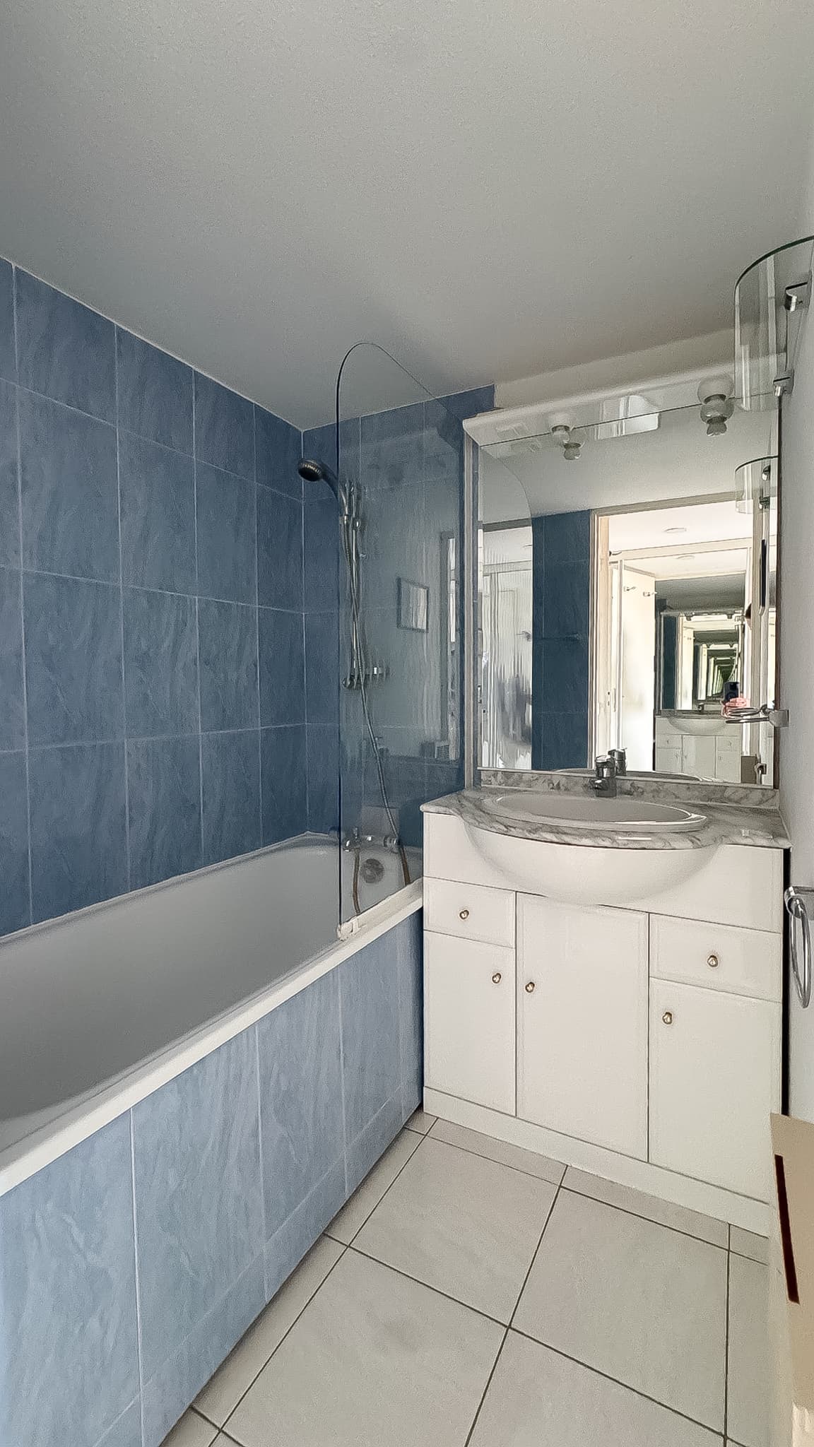 Salle de bain avec baignoire-douche dans un appartement à vendre à Port-Grimaud, finitions soignées.