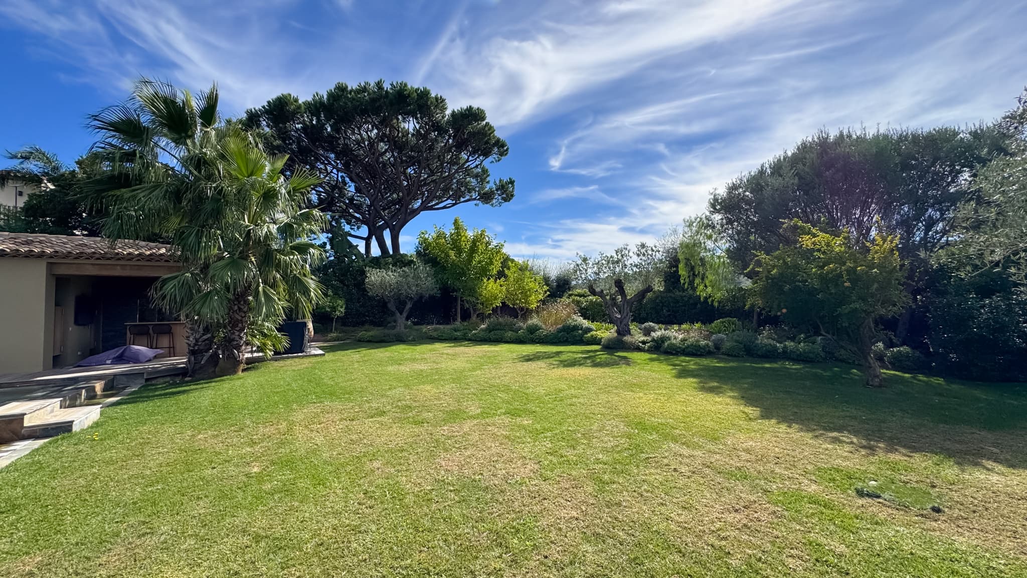 Jardin paysager soigneusement aménagé entourant cette villa de luxe à vendre à Saint-Tropez dans un domaine privé sécurisé.