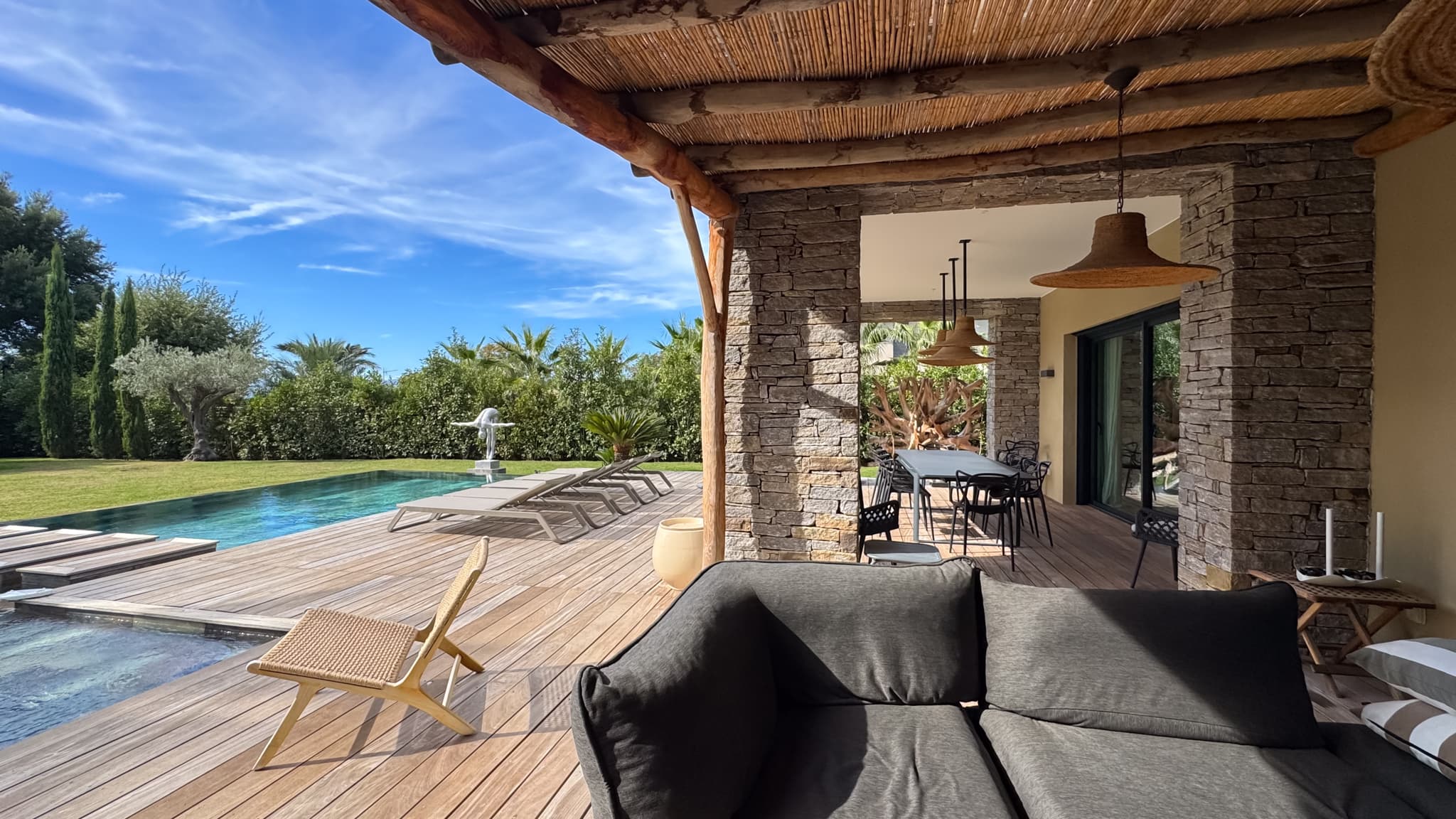 Spacieuse terrasse ouverte sur le jardin et la piscine dans cette villa de luxe à vendre à Saint-Tropez, située dans un domaine privé sécurisé proche du centre.