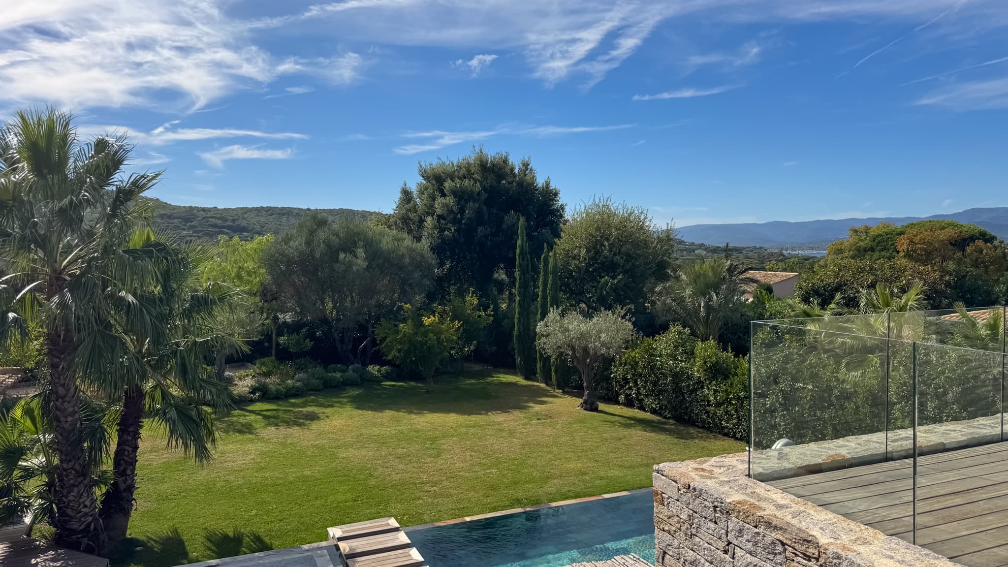 Vue dégagée sur le jardin paysager depuis cette villa de luxe à vendre à Saint-Tropez, idéalement située dans un domaine privé sécurisé à pied du village.